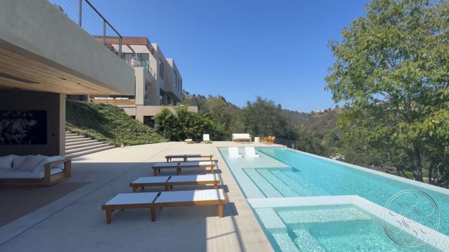 Modern 527 - exterior, modern architectural style, infinity pool, concrete pool deck, wooden lounge chairs, concrete patio floor, glass balcony railing, open outdoor living space, landscaped hillside greens, sloped roof elements