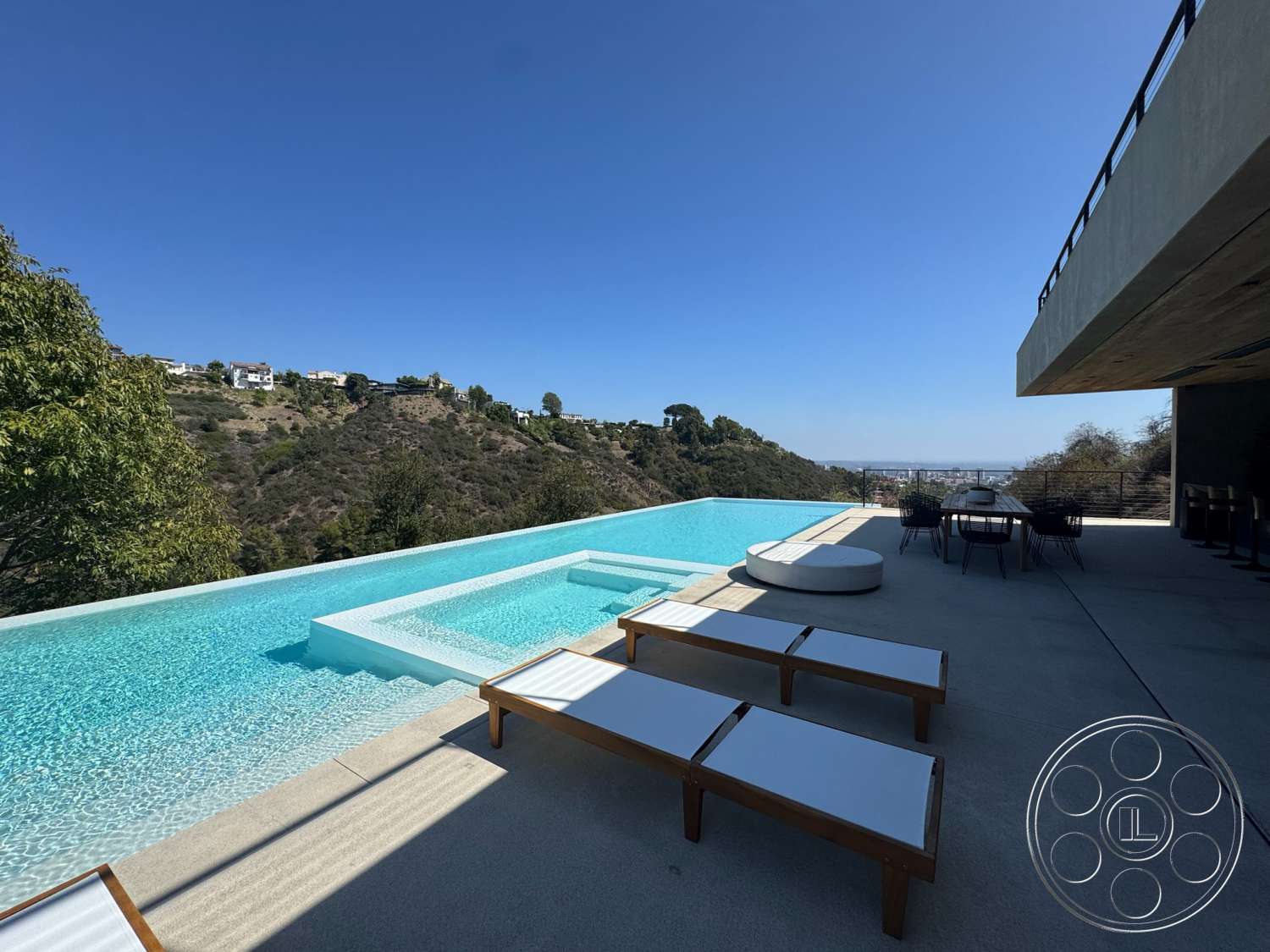 Modern 527 - exterior, minimalist design, glass railing, outdoor dining area, modern architectural style, infinity pool, concrete patio flooring, concrete pool border, landscaped hillside view, wooden sun loungers, circular outdoor sofa, horizontal wooden paneling