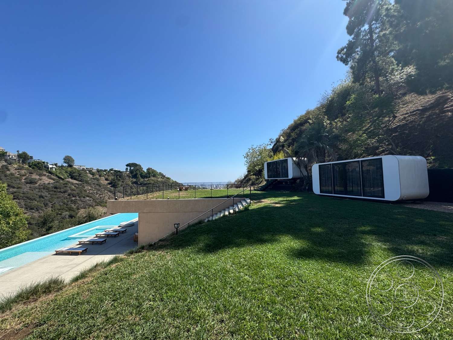 Modern 527 - modern architecture, minimalist design, landscaped yard, ocean view, sun loungers, green grass lawn, concrete pool deck, hillside location, floor-to-ceiling glass windows, rectangular infinity pool, fenced outdoor area, two standalone units