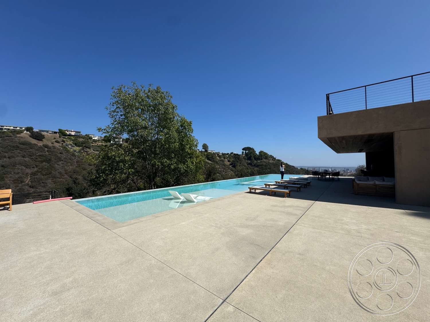 Modern 527 - exterior, modern architecture, minimalist design, sun loungers, infinity pool, outdoor living area, concrete patio flooring, stucco exterior walls, glass edge of pool, landscape hillside view