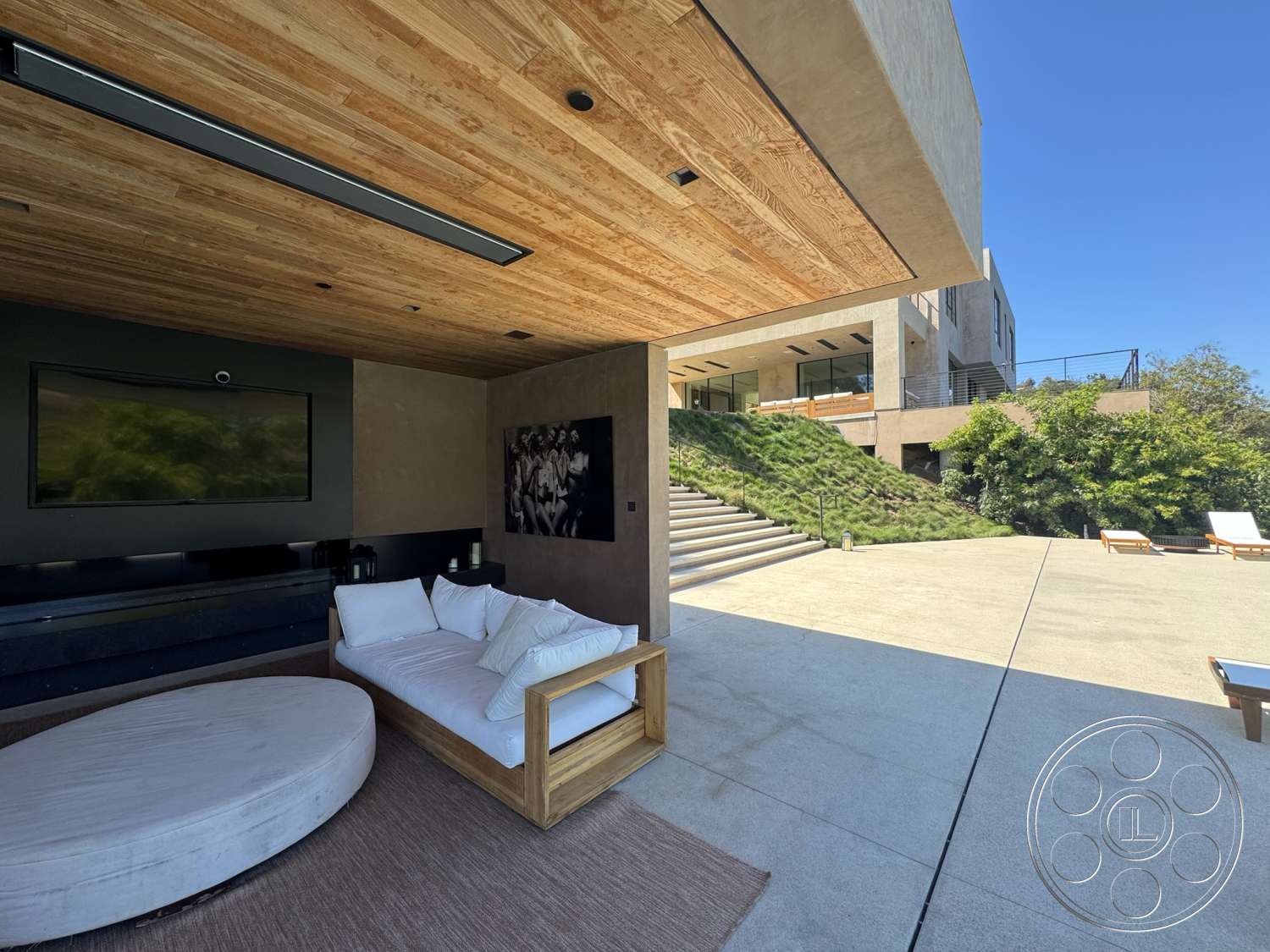 Modern 527 - exterior, horizontal siding, floor-to-ceiling windows, concrete steps, modern architectural style, landscaped hillside, concrete patio flooring, wood beam ceiling, square outdoor lounge sofa, round outdoor coffee table, black television wall unit
