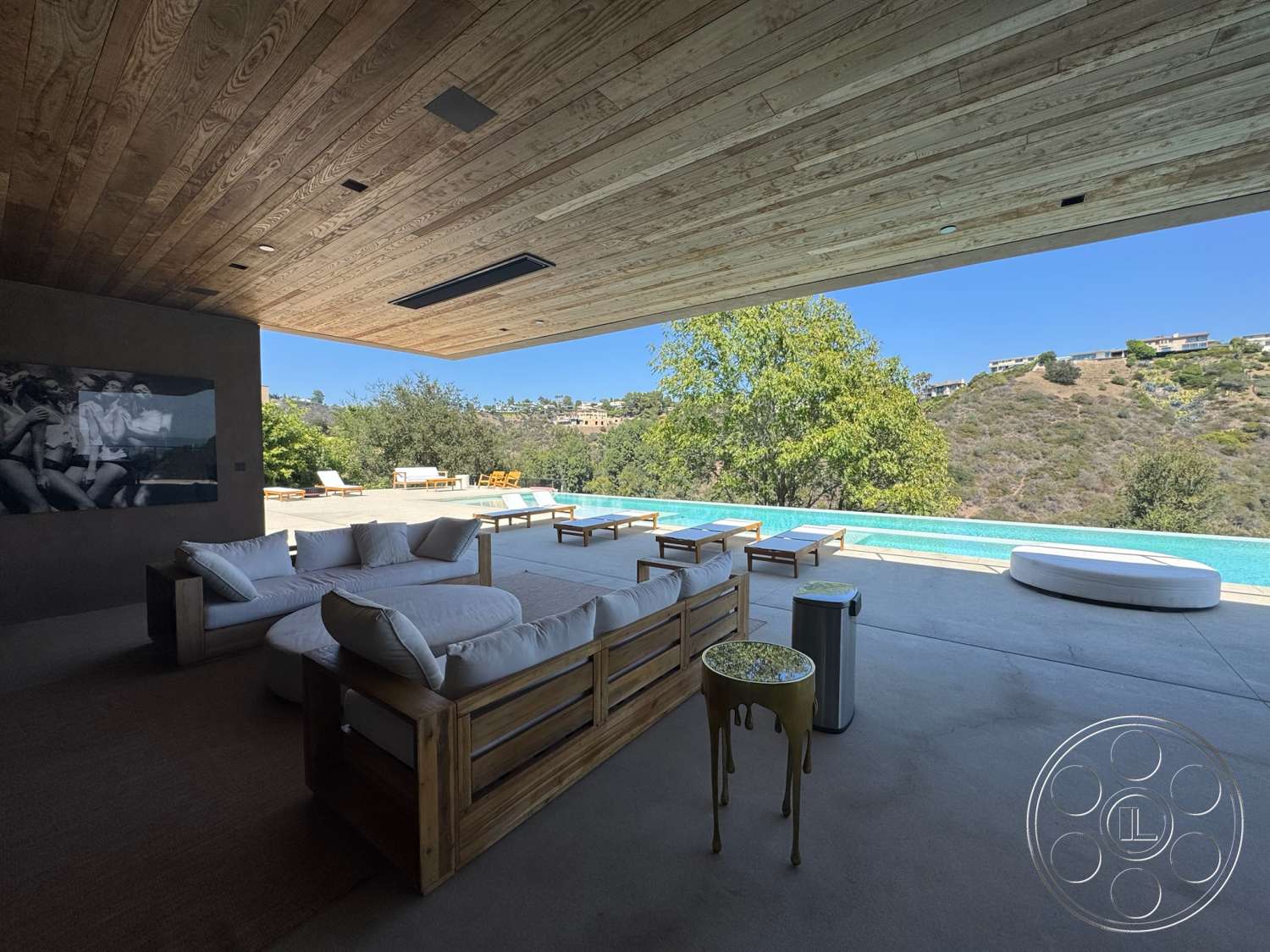 Modern 527 - textured wall art, natural wood accents, glass sliding doors, exposed concrete walls, modern outdoor lounge area, concrete patio flooring, wood beam ceiling, minimalist furniture design, rectangular infinity pool, sunny urban setting, landscaped hillside view