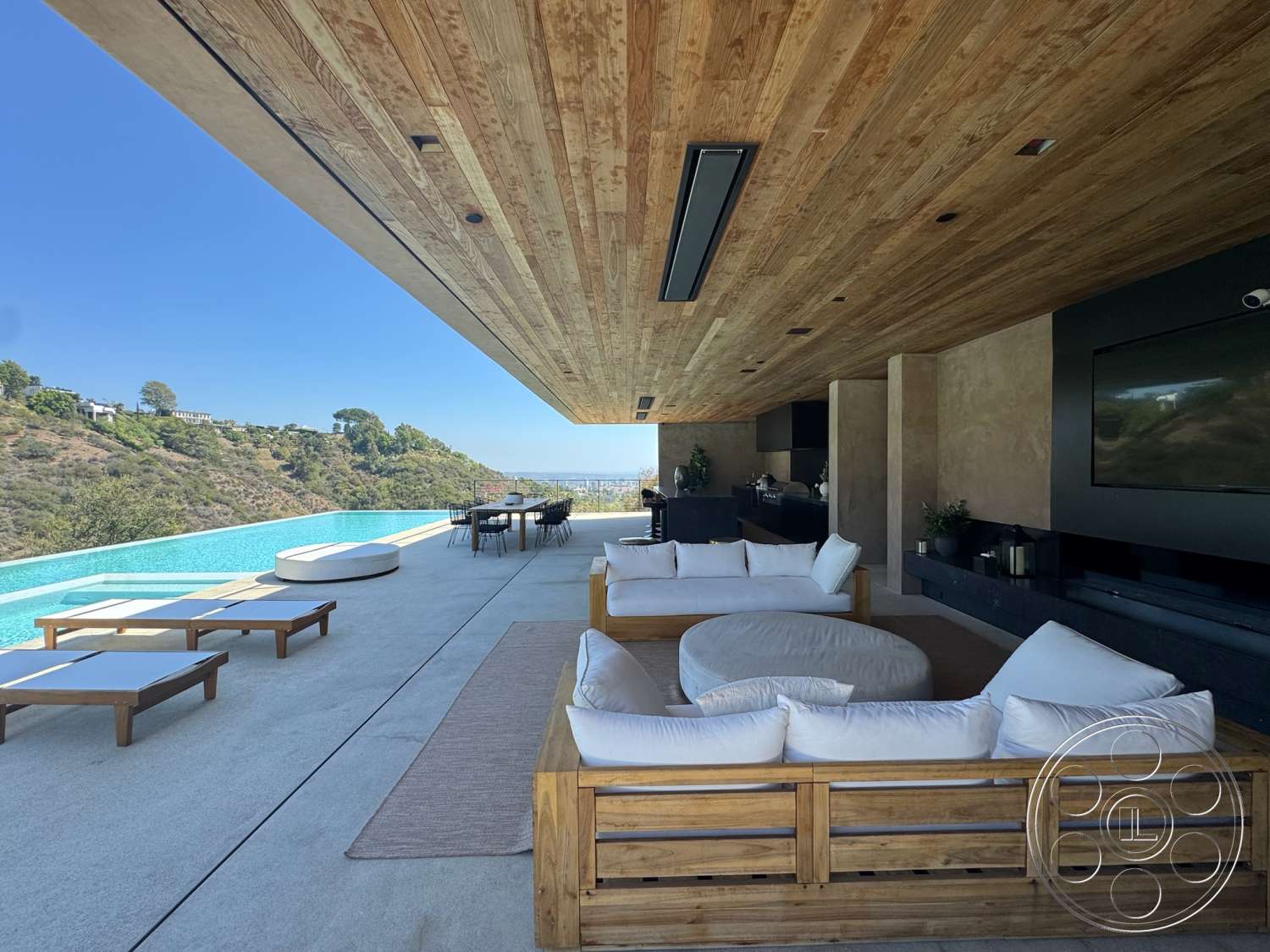 Modern 527 - exterior, minimalist design elements, modern outdoor furniture, floor-to-ceiling windows, wood ceiling panels, wood deck, infinity pool, rectangular pool, concrete patio flooring, textured plaster wall, stone fireplace wall, panoramic hillside view, open-air living area, built-in outdoor seating, landscape surrounding, sleek outdoor dining area
