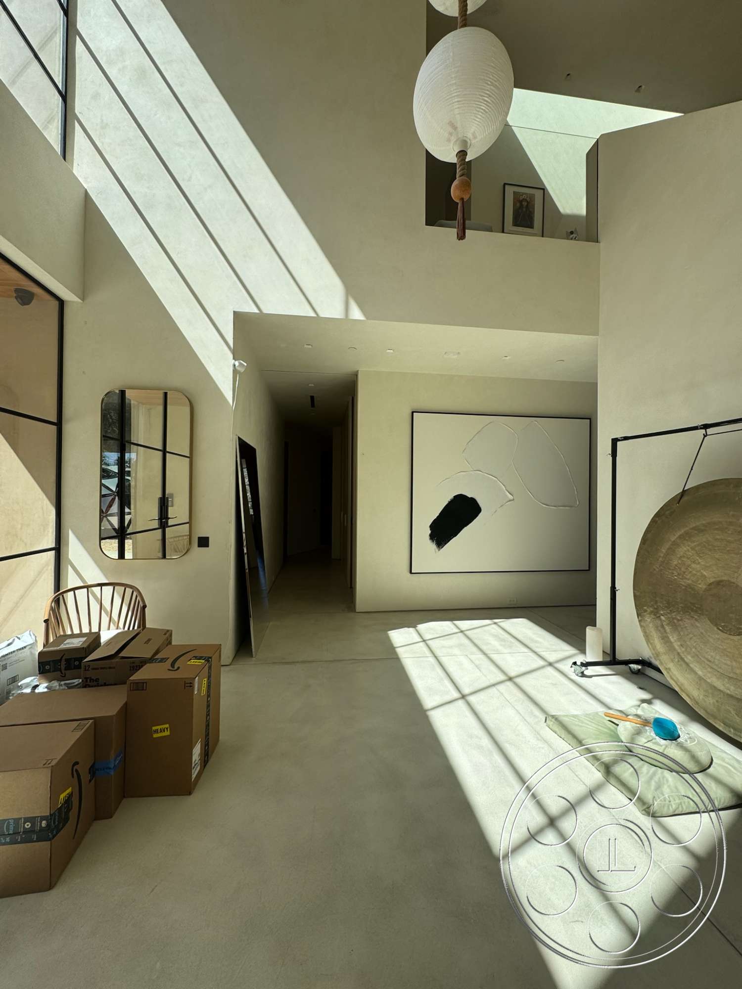 Modern 527 - neutral color palette, natural light, minimalist design, open layout, concrete flooring, modern pendant lighting, textured plaster walls, large floor-to-ceiling windows, decorative wall mirror, framed abstract wall art, wood accent details, curved accent chair, horizontal window shade lines, free-standing room divider
