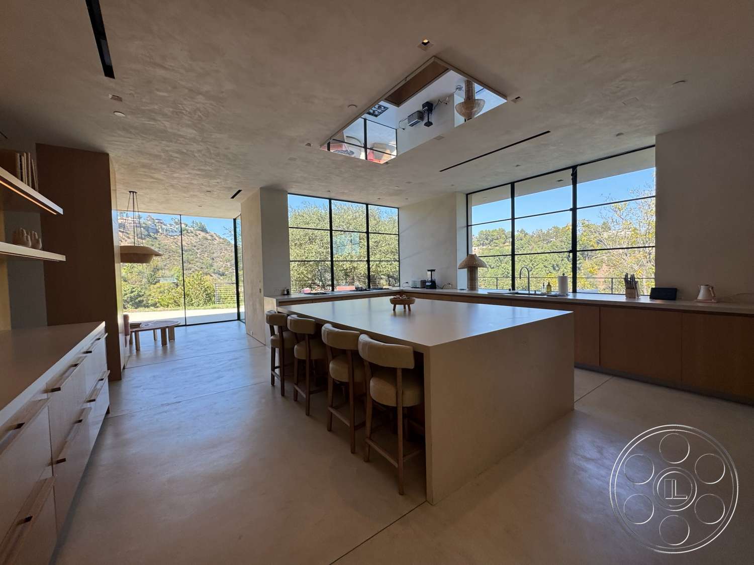 Modern 527 - natural wood cabinetry, modern pendant lighting, floor-to-ceiling windows, bright natural lighting, mountain view, exposed concrete ceiling, open-concept layout, large sliding glass doors, pantry area, interior kitchen, clean lines design, minimalist kitchen island, concrete kitchen floors, slab countertop
