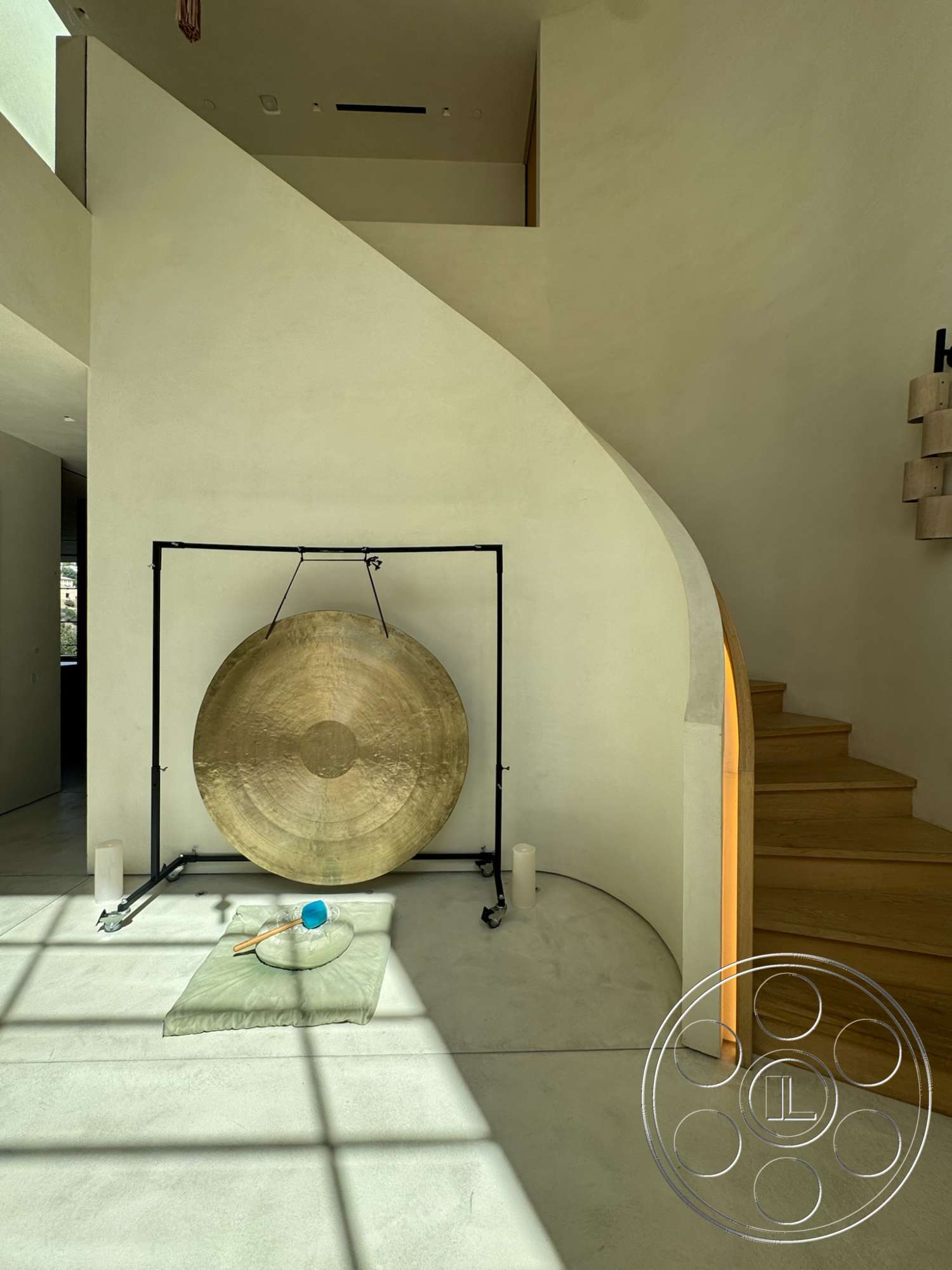 Modern 527 - floor-to-ceiling windows, contemporary architectural style, minimalist interior design, smooth plaster wall finishes, exposed concrete flooring, ambient lighting details, open foyer space, curved staircase with wooden steps, golden gong installation