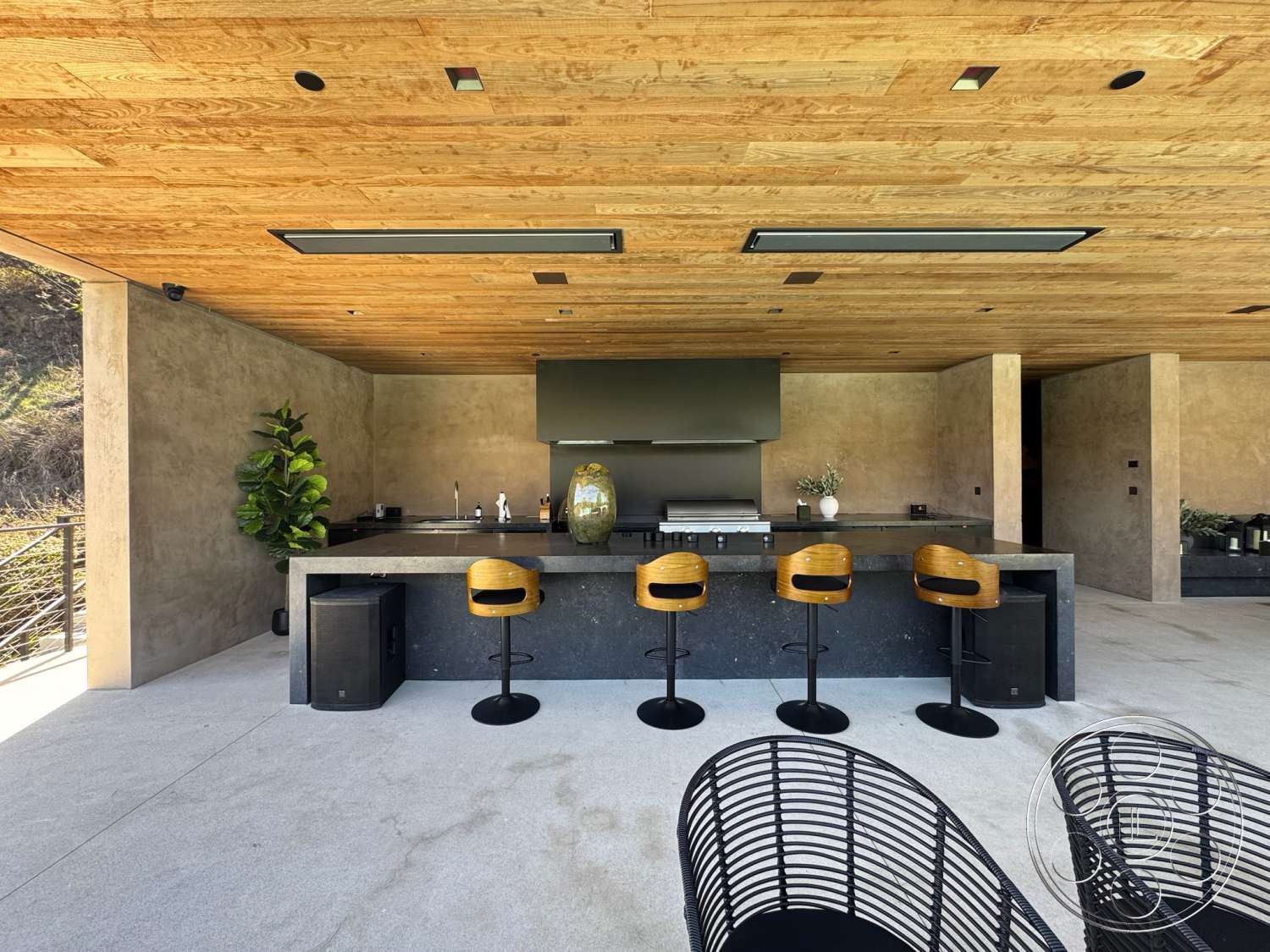 Modern 527 - exterior, minimalist design, concrete walls, modern architectural style, outdoor entertaining space, outdoor kitchen area, lush indoor plants, concrete patio flooring, textured plaster wall, wood ceiling planks, hardwood bar stools, stone countertop island, black marble bar area, steel railing accents