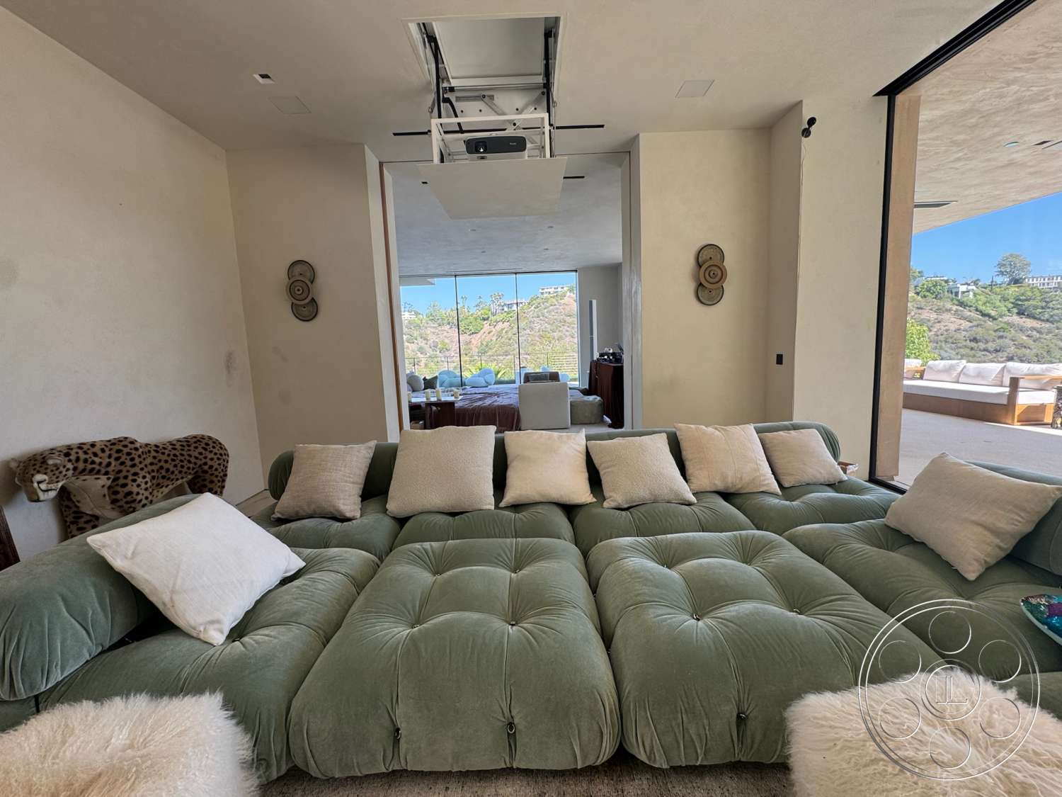Modern 527 - natural light, textured plaster walls, large floor-to-ceiling windows, wood accent elements, contemporary interior design, comfortable lounge area, minimalist wall treatment, plush tufted green sofa, pillow seating