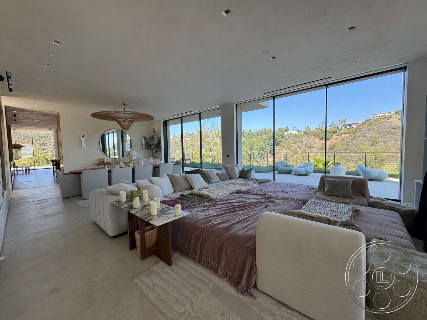 Modern 527 - neutral color palette, large glass sliding doors, open floor plan, concrete flooring, modern furnishings, exposed concrete walls, floor-to-ceiling windows, decorative throw pillows, interior dining area, minimalist furniture arrangement, natural hillside view, round wooden ceiling light fixture, soft textured area rug