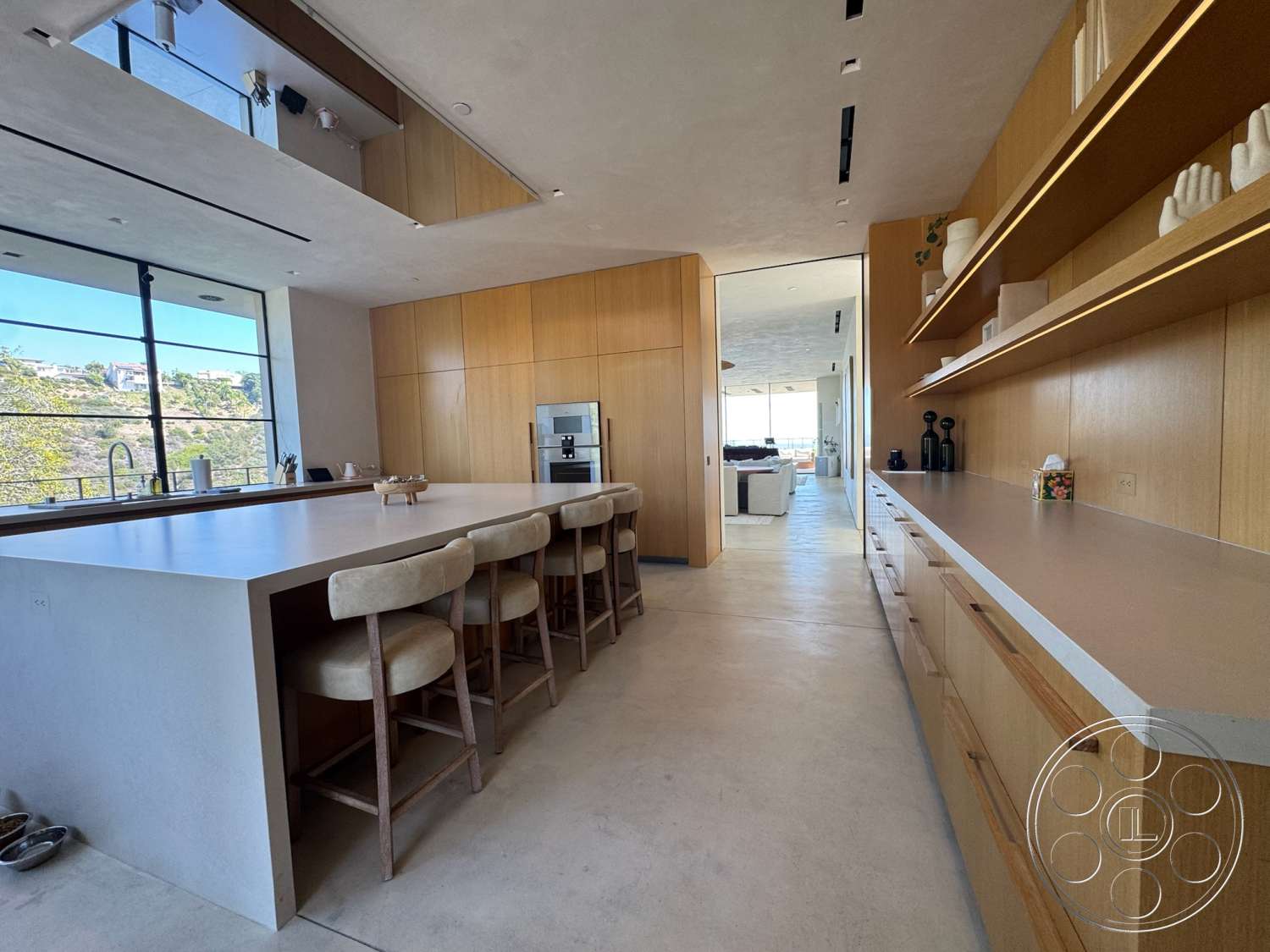 Modern 527 - neutral color palette, natural light, minimalist design, stainless steel appliances, floor-to-ceiling windows, modern bar stools, plaster wall finish, concrete kitchen island, open kitchen layout, wooden kitchen cabinetry, concrete kitchen floors, light wood shelves