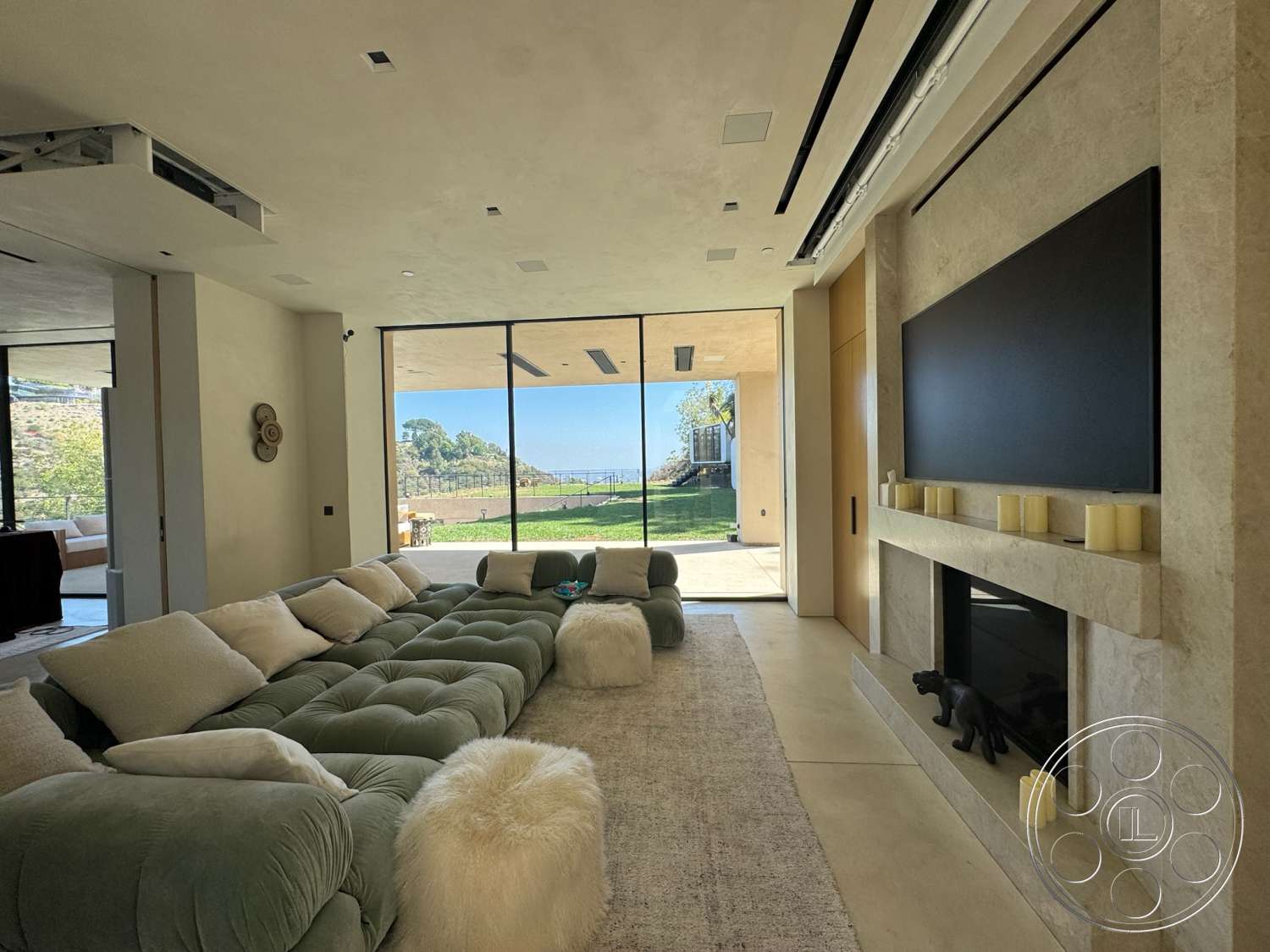 Modern 527 - neutral color palette, concrete flooring, floor-to-ceiling windows, textured plaster walls, stone feature wall, open floor plan layout, light-colored area rug, built-in media unit, modern sofa with rounded edges, linear lighting ceiling fixtures, minimalist decorative wall accents, panoramic view of outdoor landscape