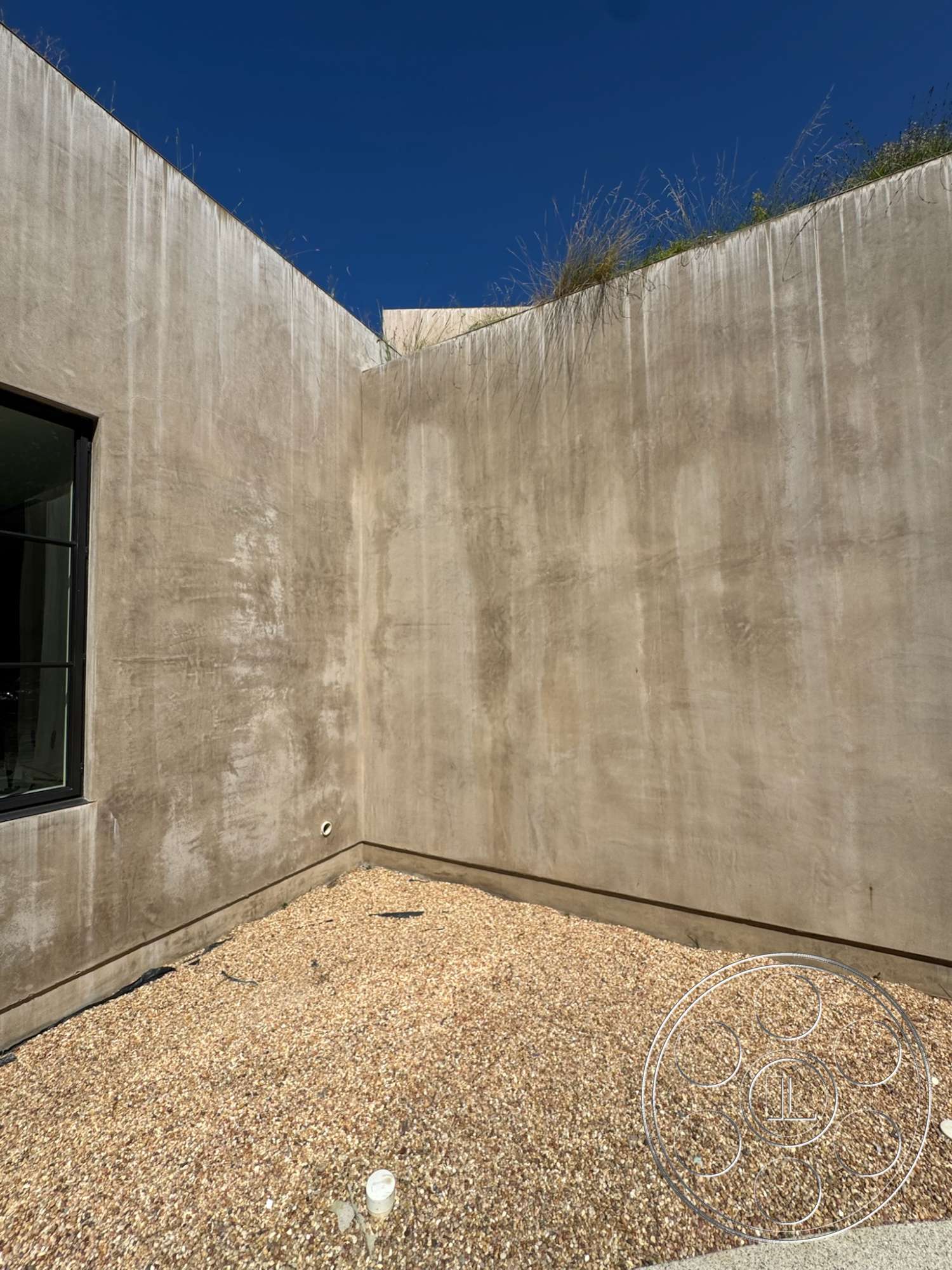 Modern 527 - exterior, minimalist design, concrete walls, floor-to-ceiling windows, natural elements, gravel landscaping, rectangular space, smooth concrete finish, blue sky backdrop