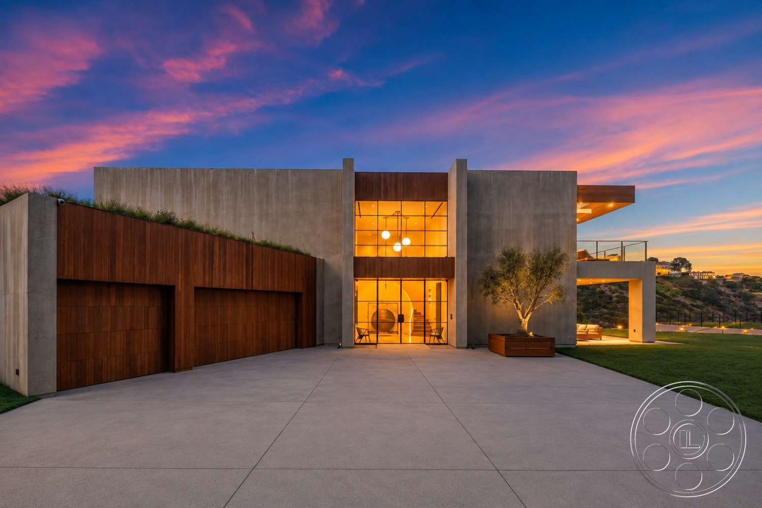 Modern 527 - exterior, concrete walls, floor-to-ceiling windows, modern architectural style, concrete driveway, minimalistic design elements, landscaped green lawn, sunset sky backdrop, wood paneling garage doors, rectangular home shape, glass railing deck, abstract lighting fixtures