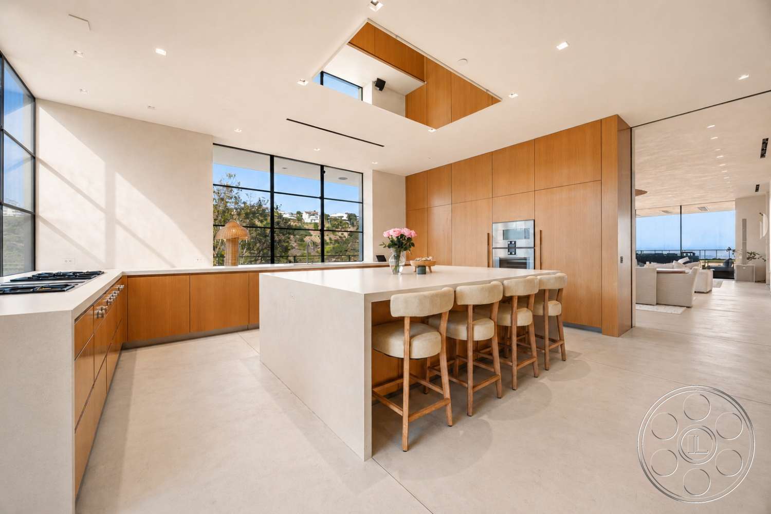 Modern 527 - minimalist decor, open concept layout, light wood cabinetry, floor-to-ceiling windows, textured plaster walls, built-in kitchen appliances, natural light flooding the space, concrete kitchen countertops, light-colored concrete flooring, modern island bar with seating