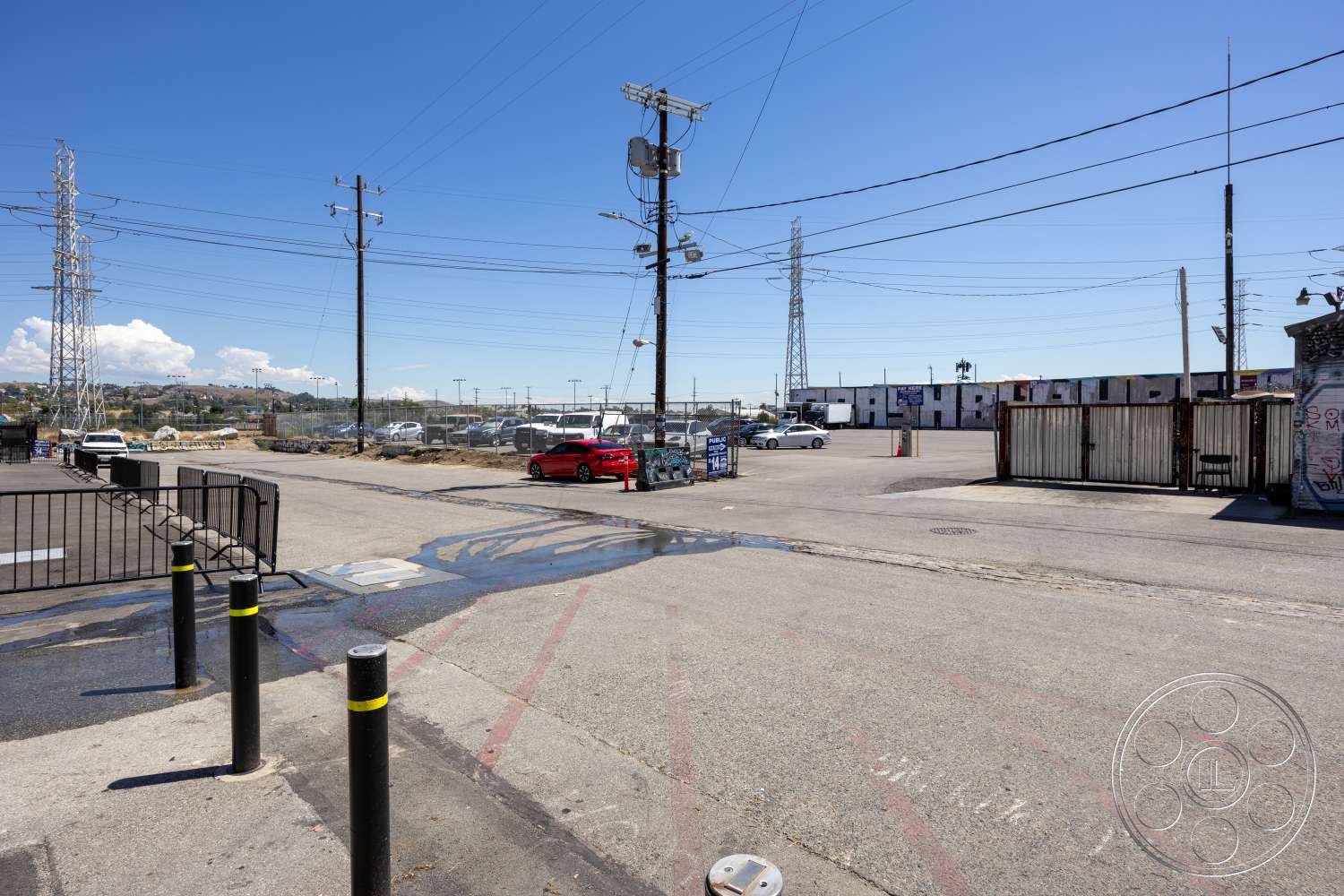 Club 74 - exterior, clear blue sky, power lines, asphalt parking lot, surrounding urban landscape, metal fences, concrete utility poles, industrial background, various vehicles