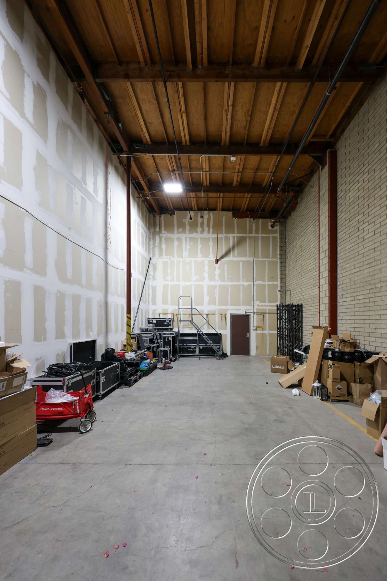 Club 74 - concrete flooring, steel support columns, exposed wooden ceiling beams, drywall interior walls, industrial warehouse space, finished ceiling