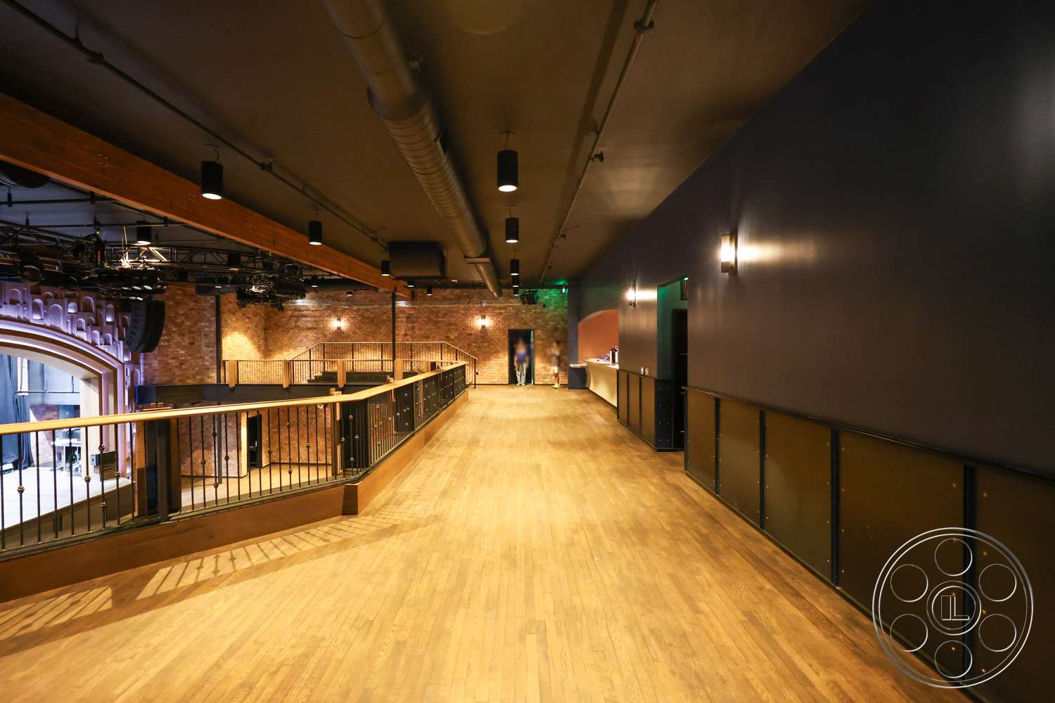 Club 74 - recessed lighting, open walkway, exposed brick wall, wooden floor, performance area, black metal railings, modern railing, dark painted walls, wood beam ceiling, industrial style architecture, sound equipment overhead