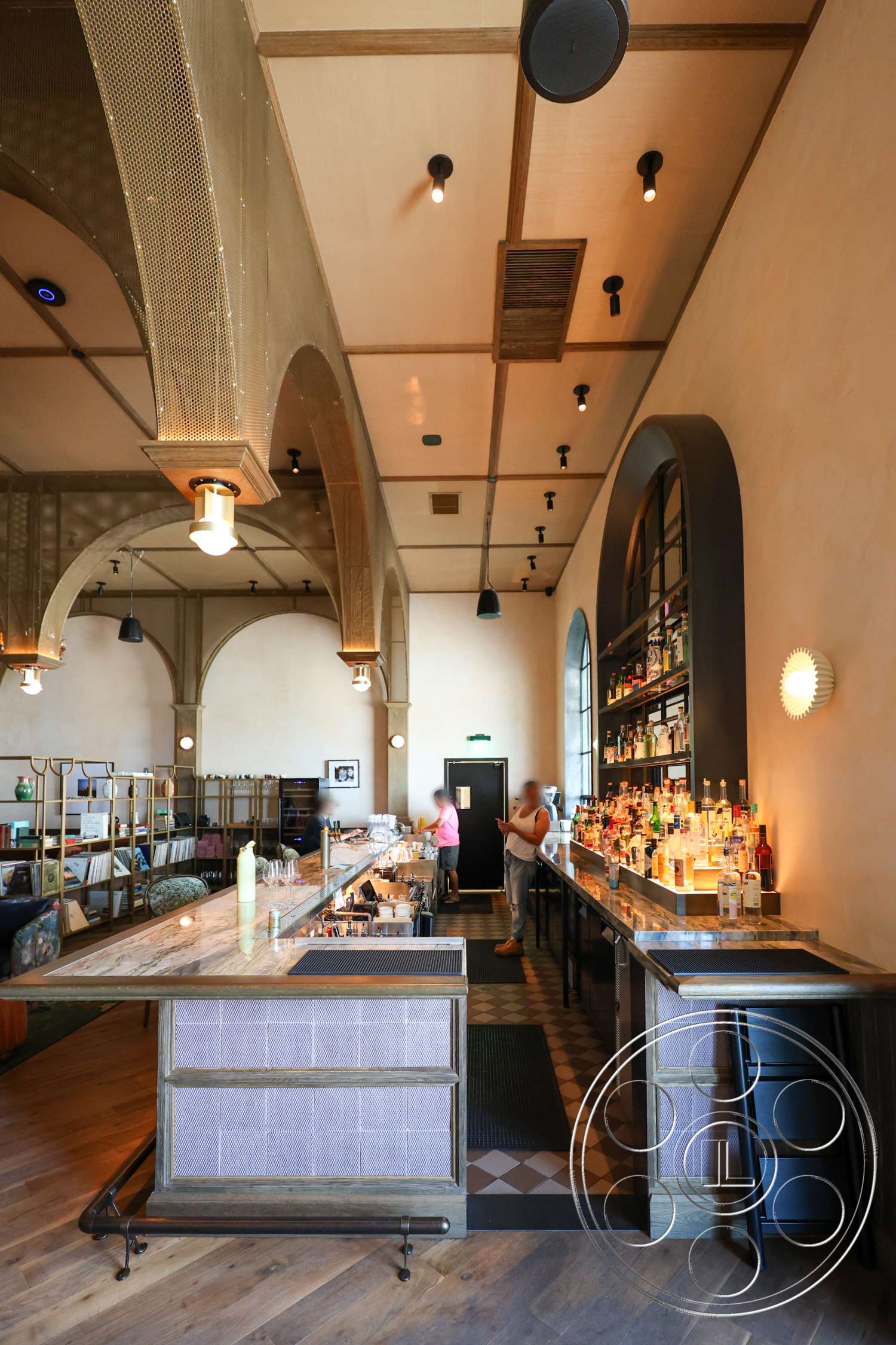 Club 74 - light wood flooring, floor-to-ceiling windows, textured plaster walls, marble bar top, decorative wall accents, hexagonal tile flooring, wood beam ceiling, industrial pendant lighting, custom built-in shelving, exposed arches, black metal bar railings, open bar area