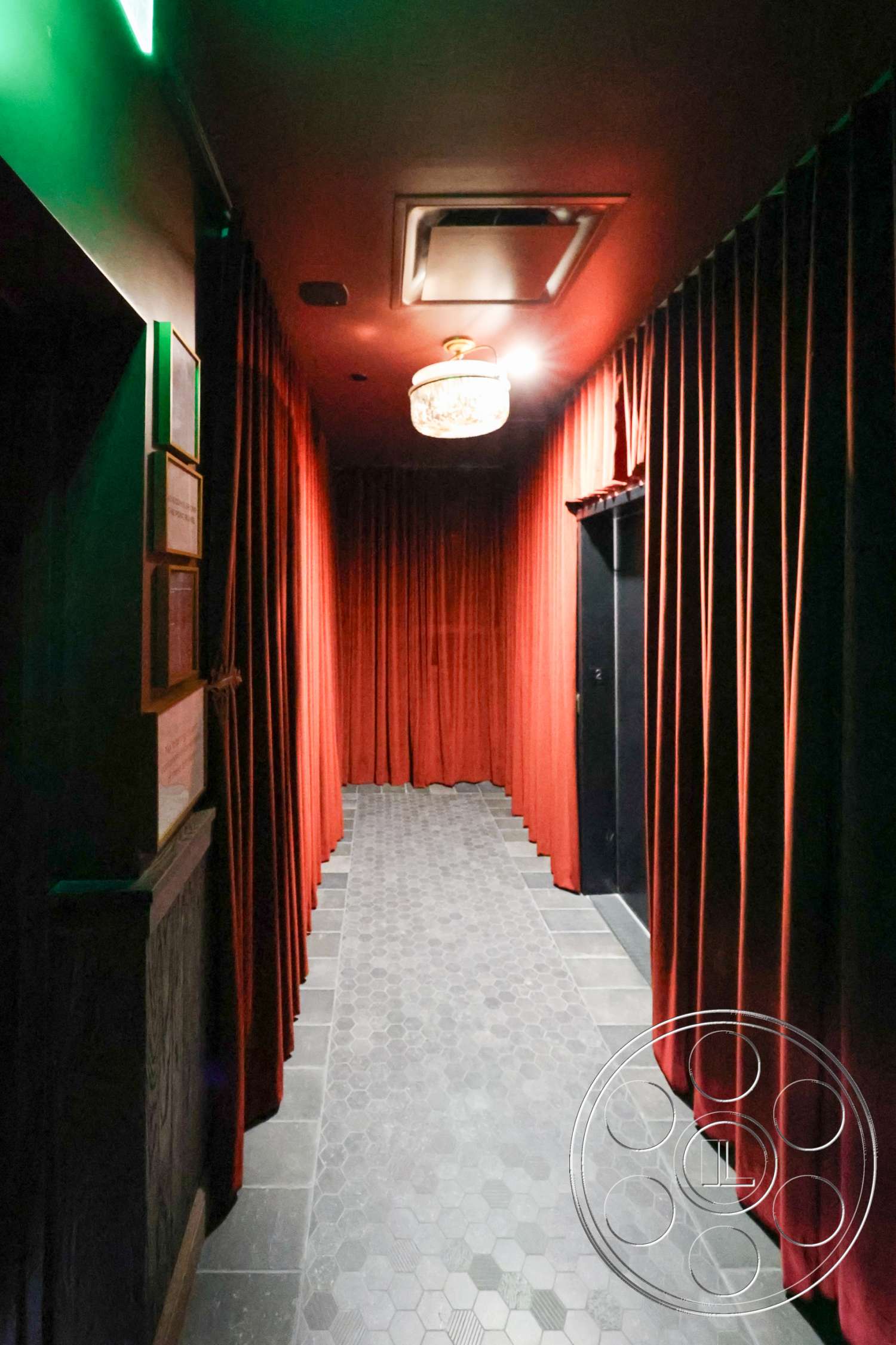 Club 74 - hexagon tile flooring, ambient lighting, black door, art deco style, decorative wall paneling, dark painted walls, interior corridor, chandelier lighting fixture, red velvet curtains, dark tile hallway floor