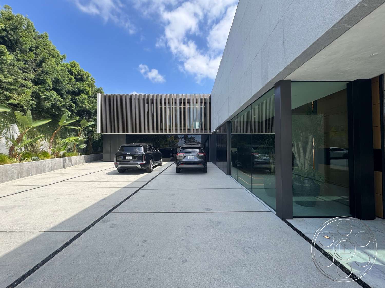 The Bellagio Estate - exterior, minimalist design, open space layout, modern architectural style, concrete driveway, glass wall, poured concrete surface, landscape planting beds, granite facade, metal slatted awning, rectangular shape