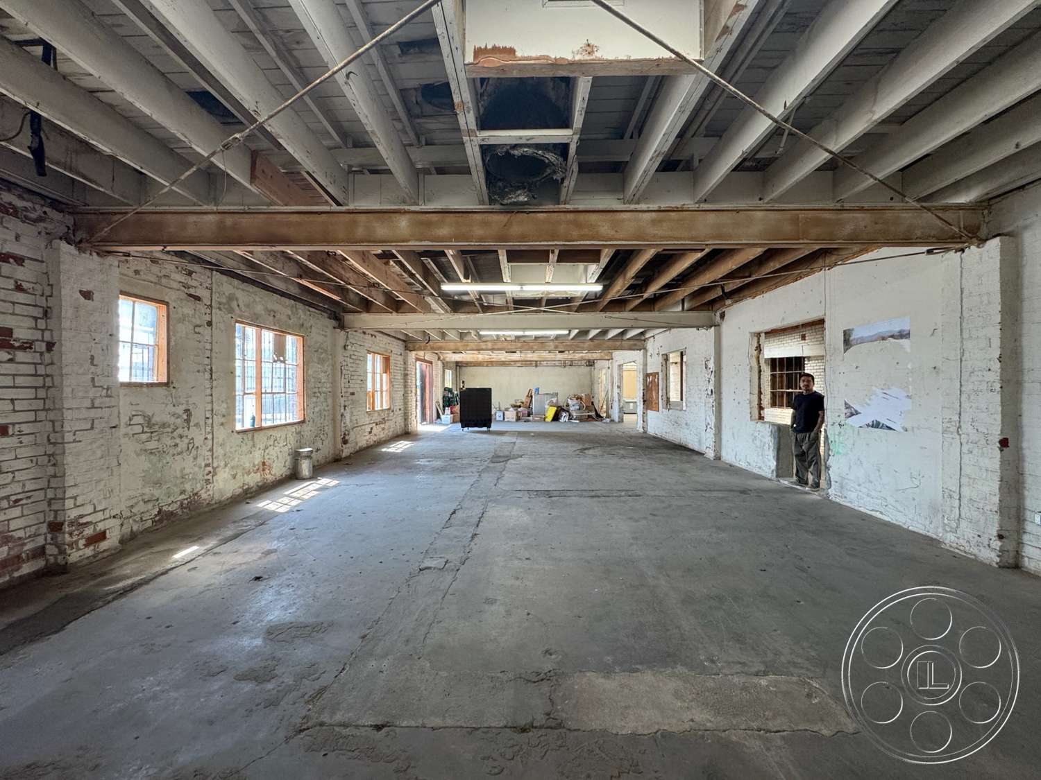 Warehouse 62 - large windows, natural light, open floor plan, concrete floor, interior space, industrial style, exposed brick walls, high ceiling, wood beam ceiling
