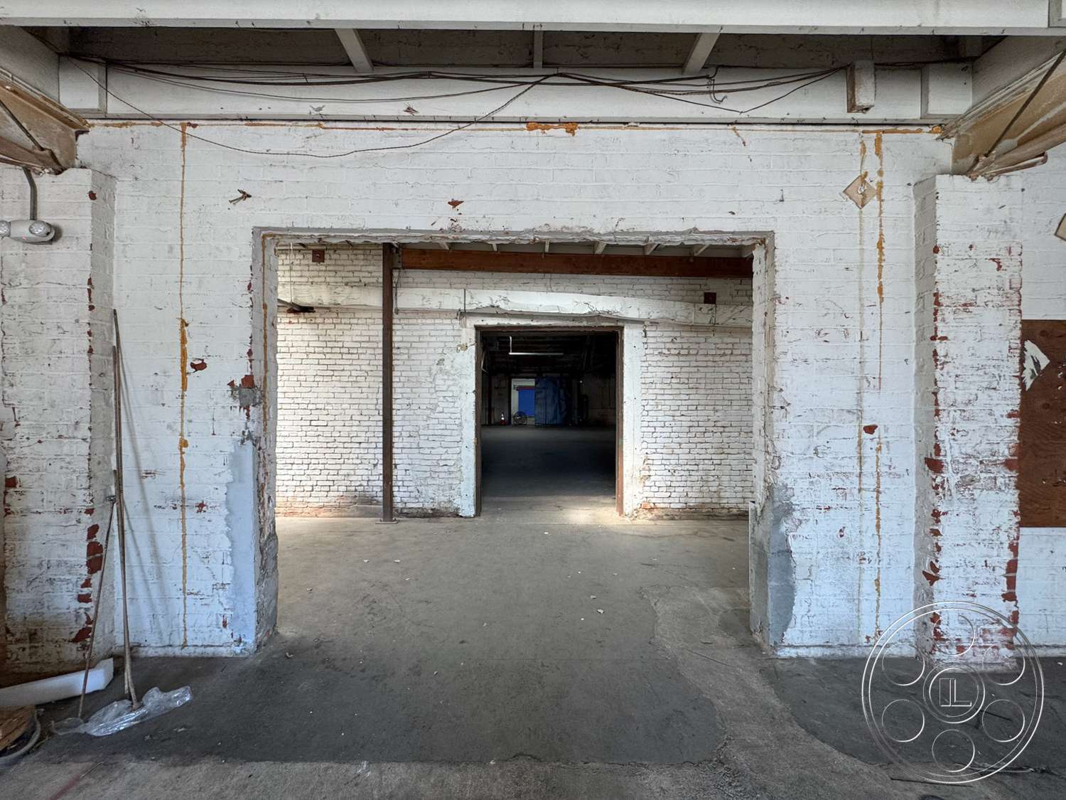 Warehouse 62 - neutral color palette, open floor plan, concrete flooring, exposed brick walls, large doorways, industrial ceiling beams, rustic wall treatment