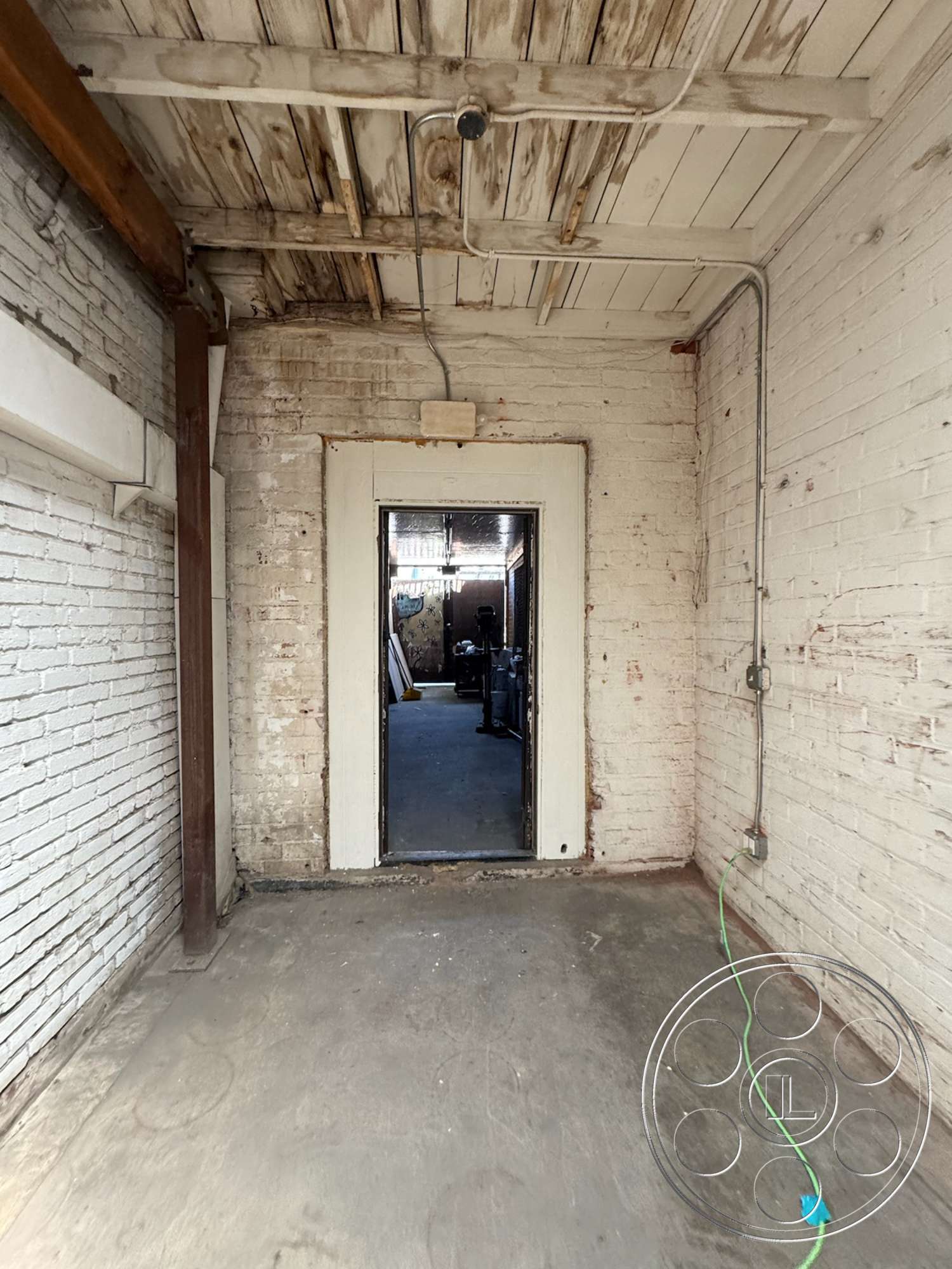 Warehouse 62 - concrete floor, industrial style, exposed brick walls, wood beam ceiling, doorway opening