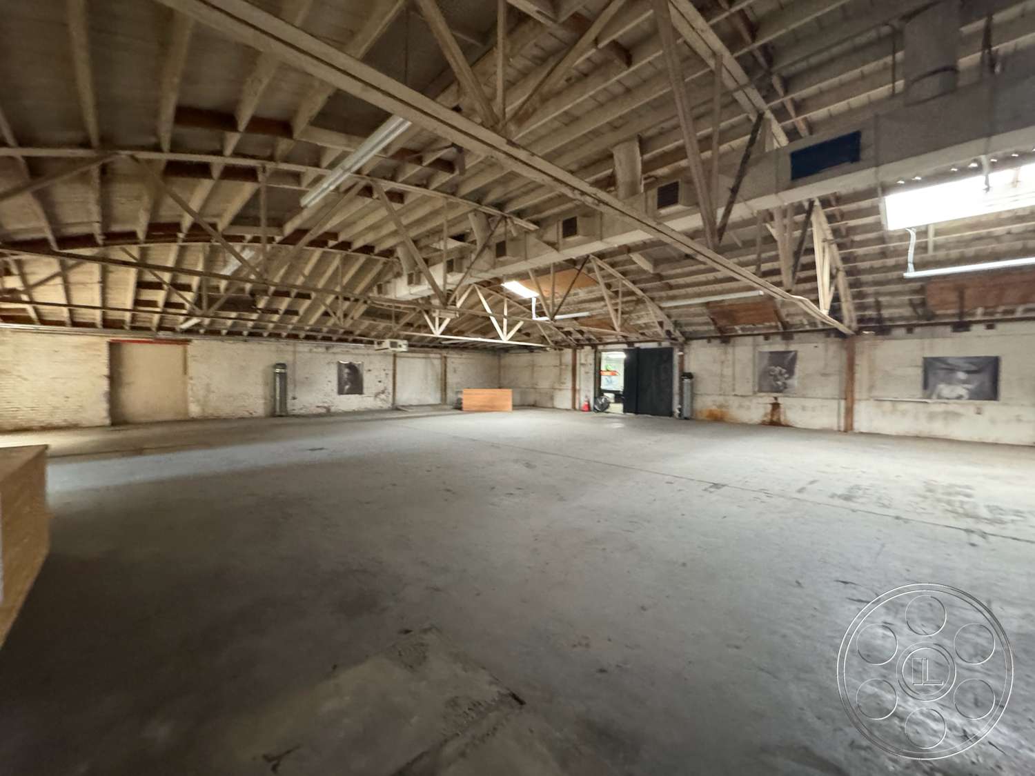 Warehouse 62 - recessed lighting, open layout, concrete floor, industrial style, brick walls, large open space, exposed wood ceiling beams