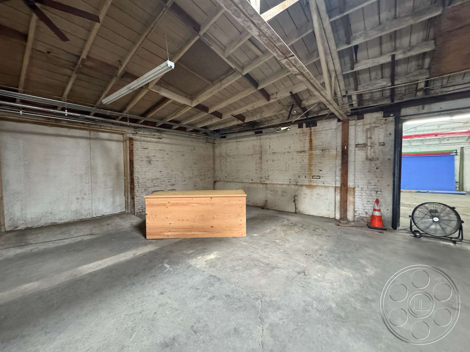 Warehouse 62 - concrete floor, industrial style, high ceiling, wooden countertop, exposed wood ceiling beams, brick interior walls, open warehouse space