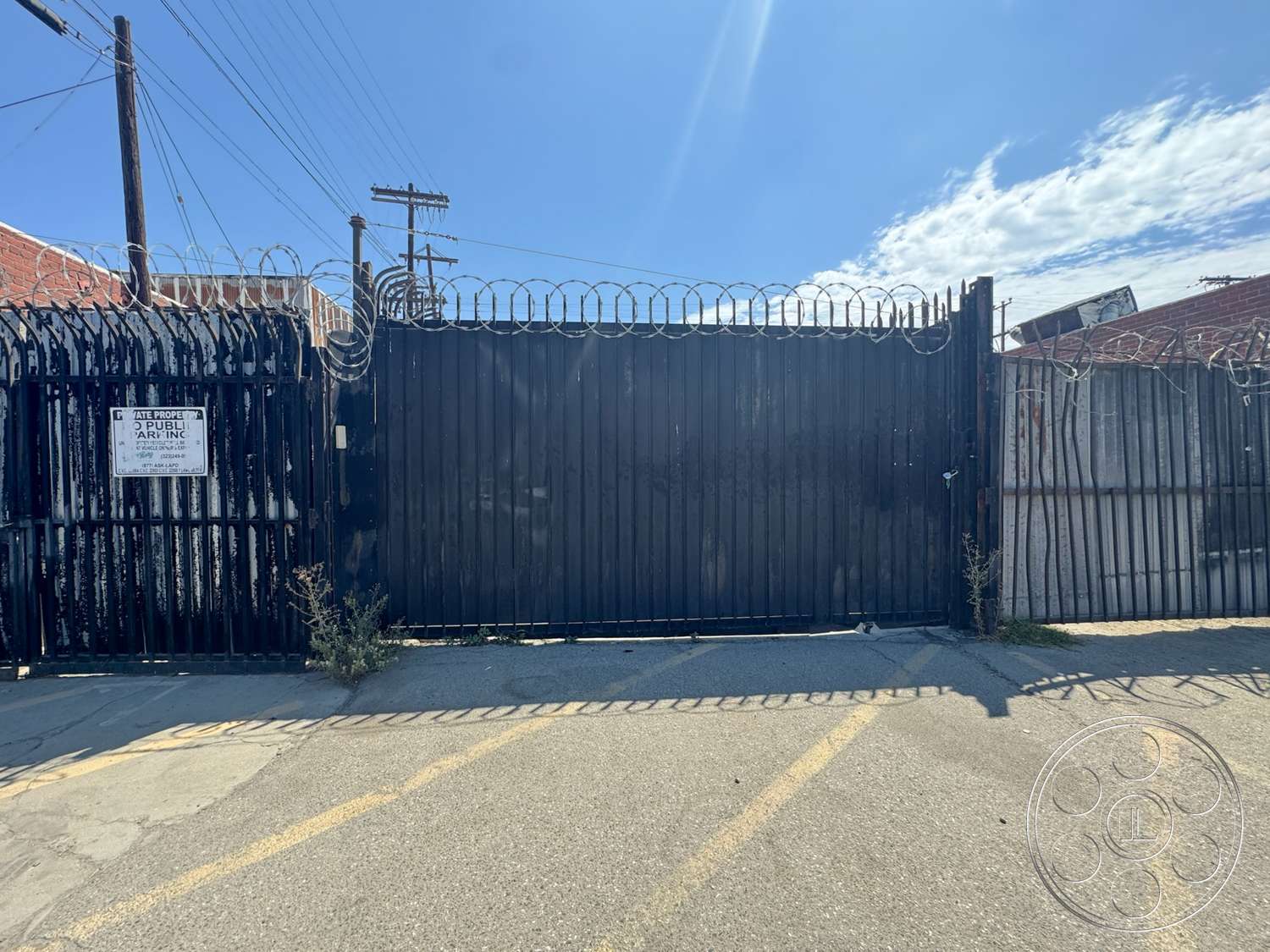 Warehouse 62 - concrete pavement, urban setting, asphalt driveway, industrial environment, metal security gate, barbed wire fencing, exterior scene