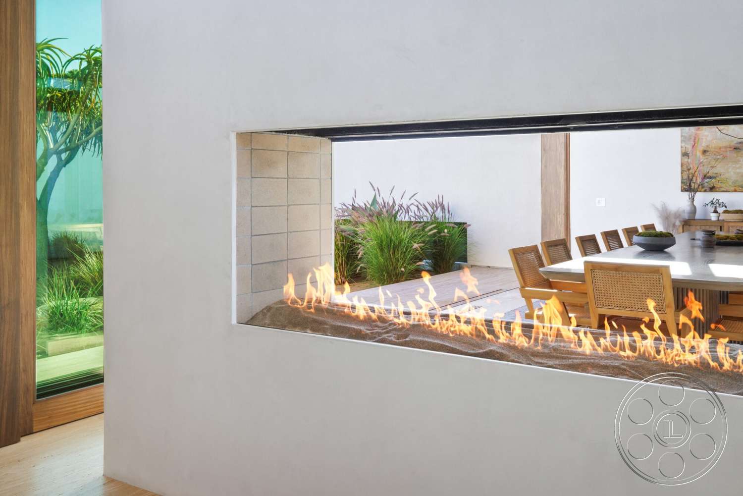 Modern 529 - natural light, minimalist aesthetic, open floor plan, large glass windows, textured plaster walls, wooden dining chairs, landscaped greenery view, concrete fireplace surround, built-in dining table, exposed linear flames, indoor outdoor connection