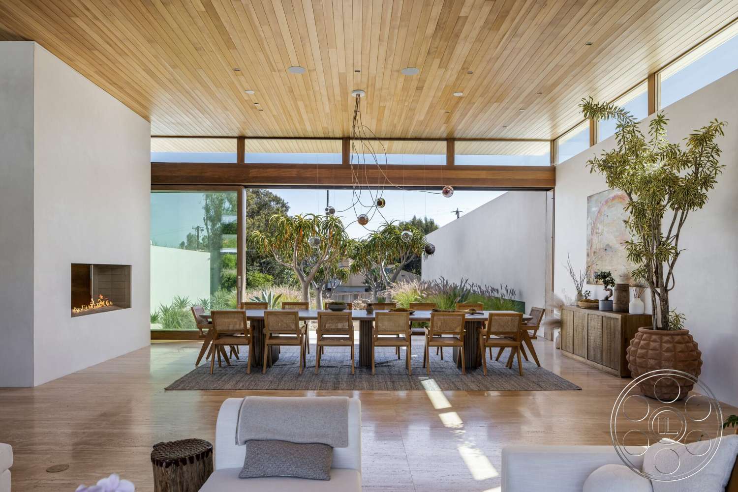 Modern 529 - natural light, minimalist design, open floor plan, exposed concrete walls, modern aesthetic, floor-to-ceiling windows, woven area rug, decorative potted plants, large dining area, wooden dining chairs, contemporary art piece, glass wall panels, wood plank ceiling, concrete fireplace surround, hardwood dining room table