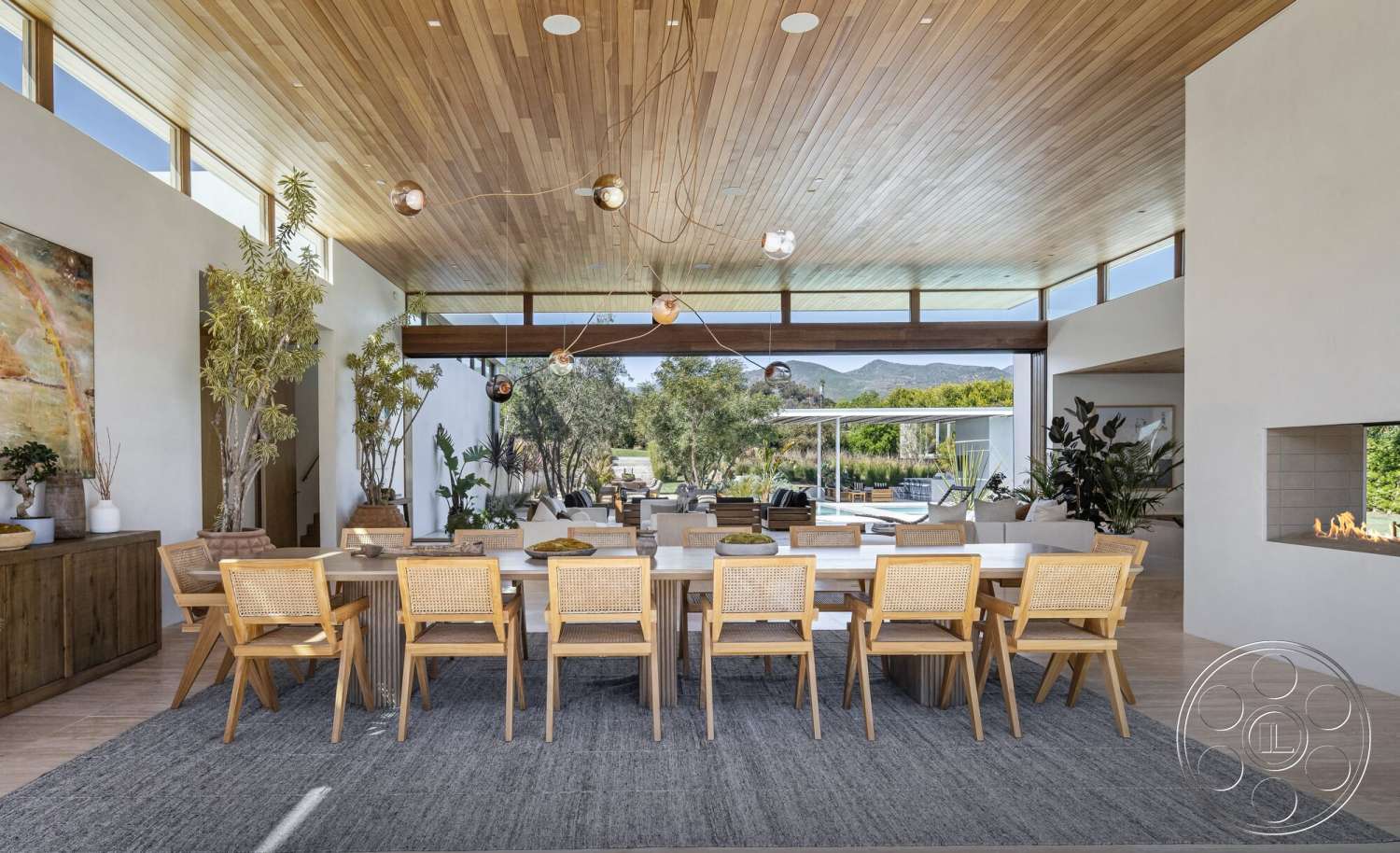 Modern 529 - indoor plants, textured area rug, light wood flooring, modern pendant lighting, large floor-to-ceiling windows, rectangular dining table, contemporary dining area, white painted walls, wood ceiling with exposed beams, minimalist fireplace wall, woven cane dining chairs