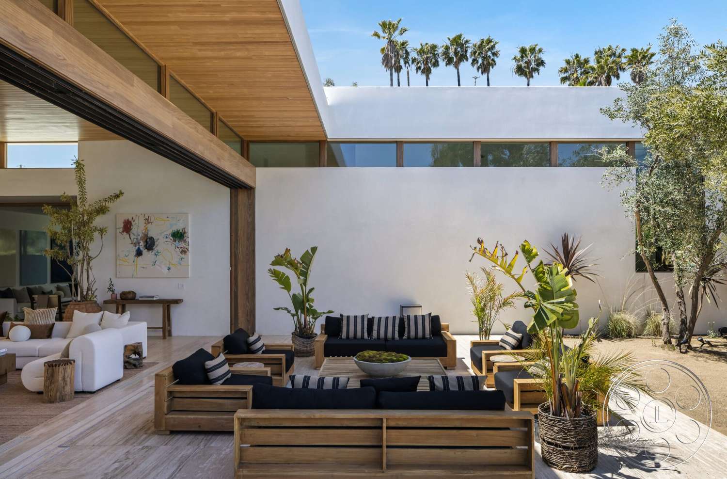 Modern 529 - large windows, exterior, white stucco walls, minimalist design, open floor plan, natural wood accents, artistic wall decor, sliding glass doors, modern outdoor seating, striped outdoor cushions, landscaped garden area, concrete patio flooring, wood beam ceiling, potted tropical plants, southwestern palm trees
