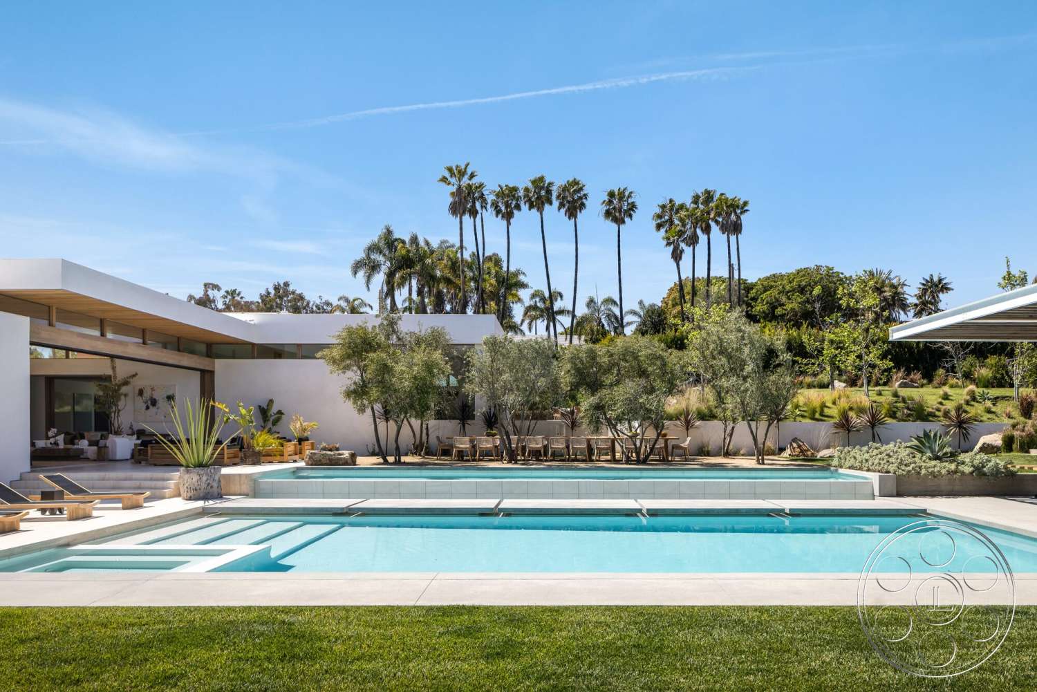 Modern 529 - exterior, white stucco walls, modern architecture, palm trees, glass sliding doors, rectangular swimming pool, outdoor seating, grass lawn, pool area, open-concept layout, flat roof design, landscaped garden area, succulent plant landscaping, concrete pool surround, wood beam overhang, sunny daytime setting, wooden patio decking