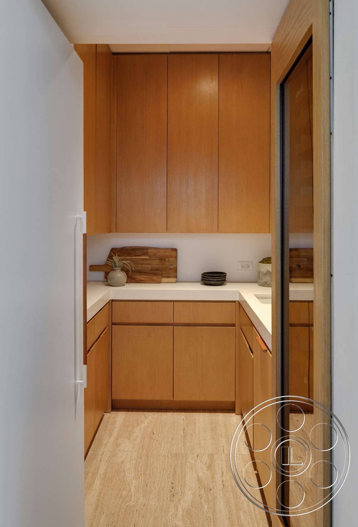 Modern 529 - natural light, glass door, wood cabinetry, kitchen island, open kitchen, textured stone floor, modern kitchen layout, minimalist kitchen design, solid surface countertops, tile kitchen flooring, light wood kitchen cabinets, cream-colored countertops, decorative wood cutting board