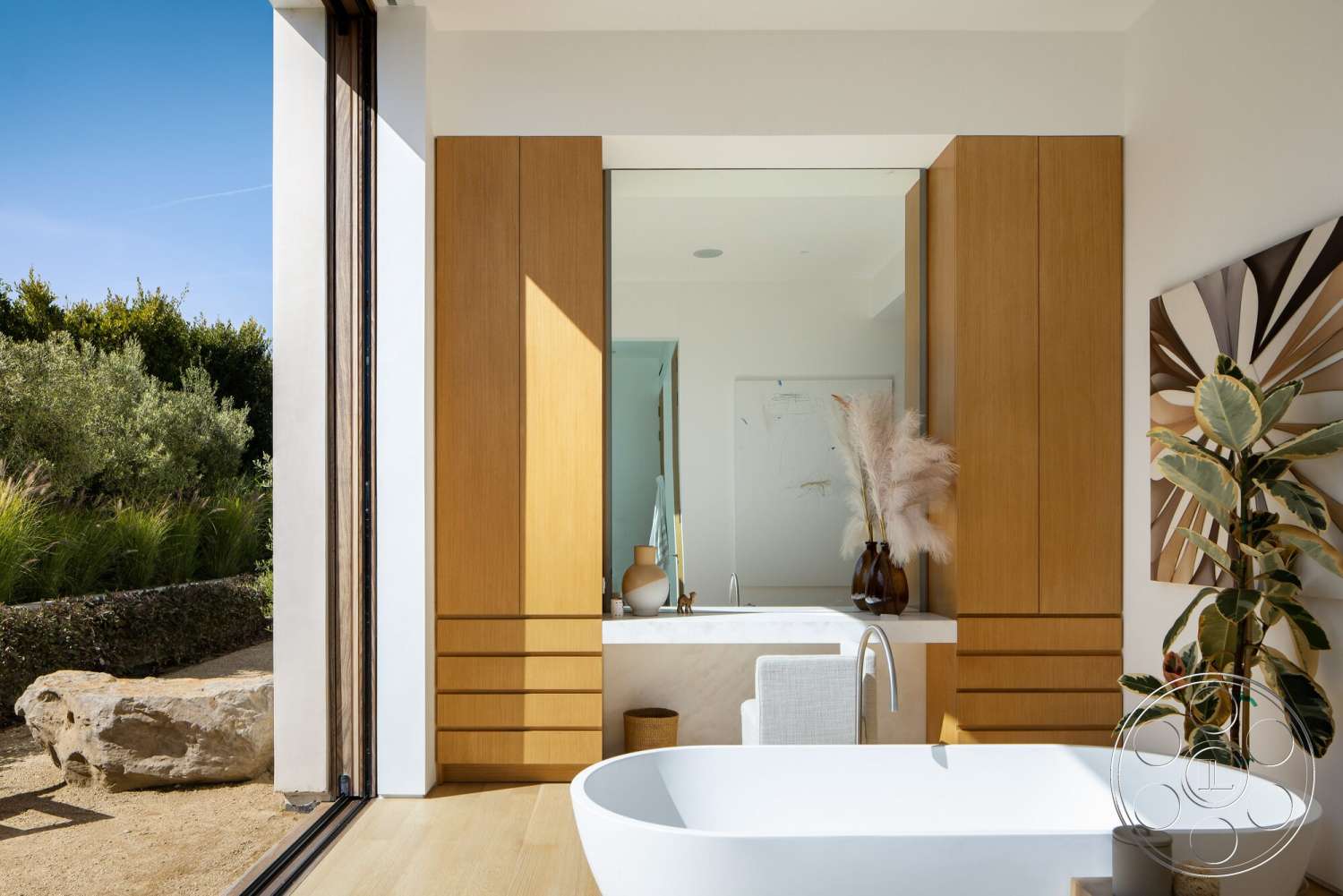 Modern 529 - neutral color palette, natural light, textured wall art, indoor plants, light wood flooring, wood cabinetry, large mirror, floor-to-ceiling windows, white freestanding bathtub, contemporary bathroom, modern minimalist design, polished stone countertop