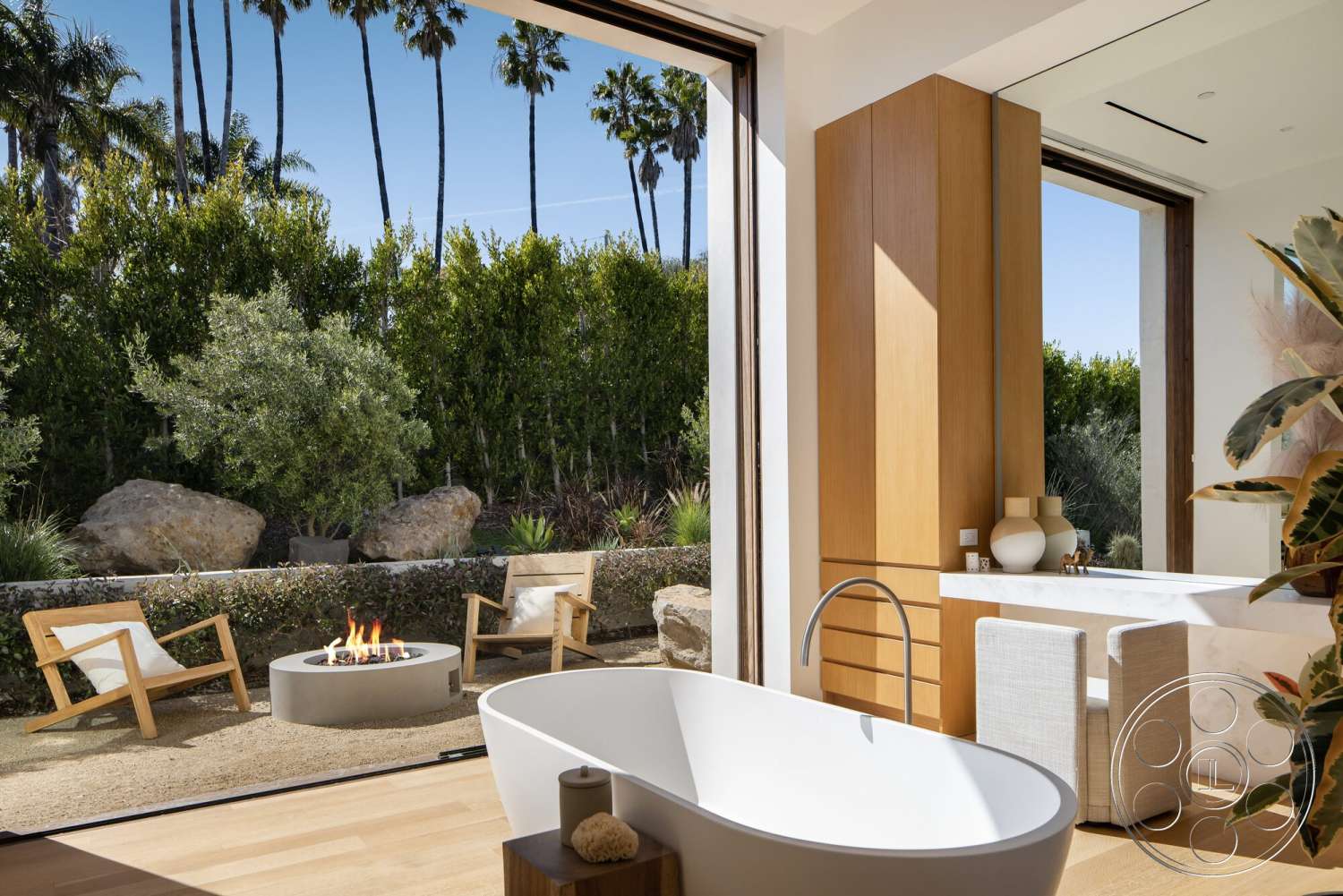 Modern 529 - light hardwood flooring, open floor plan, freestanding bathtub, minimalist design elements, tropical palm trees, lush greenery view, outdoor fire pit, modern lounge chairs, floor-to-ceiling sliding glass doors, concrete fire pit base, marble bathroom countertop, natural stone landscaping, oak wood cabinetry