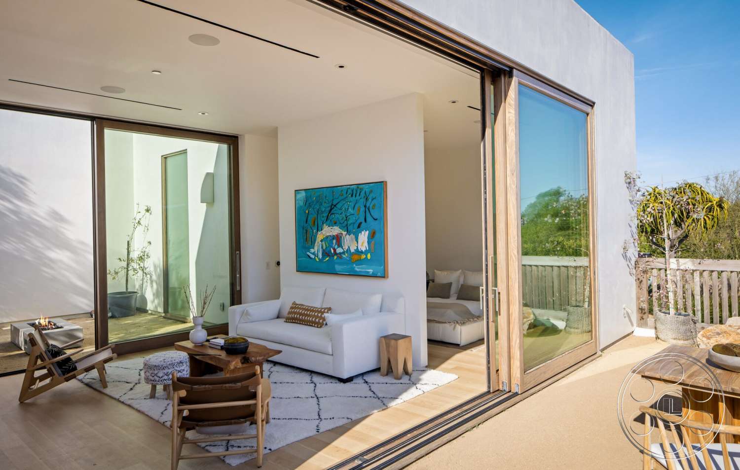 Modern 529 - hardwood flooring, exterior, minimalist design, natural lighting, plant decor, open floor plan, glass sliding doors, decorative wall art, stucco walls, white sectional sofa, modern lounge area, contemporary coffee table, wooden framing, wooden outdoor deck, round accent ottoman, scenic greenery view