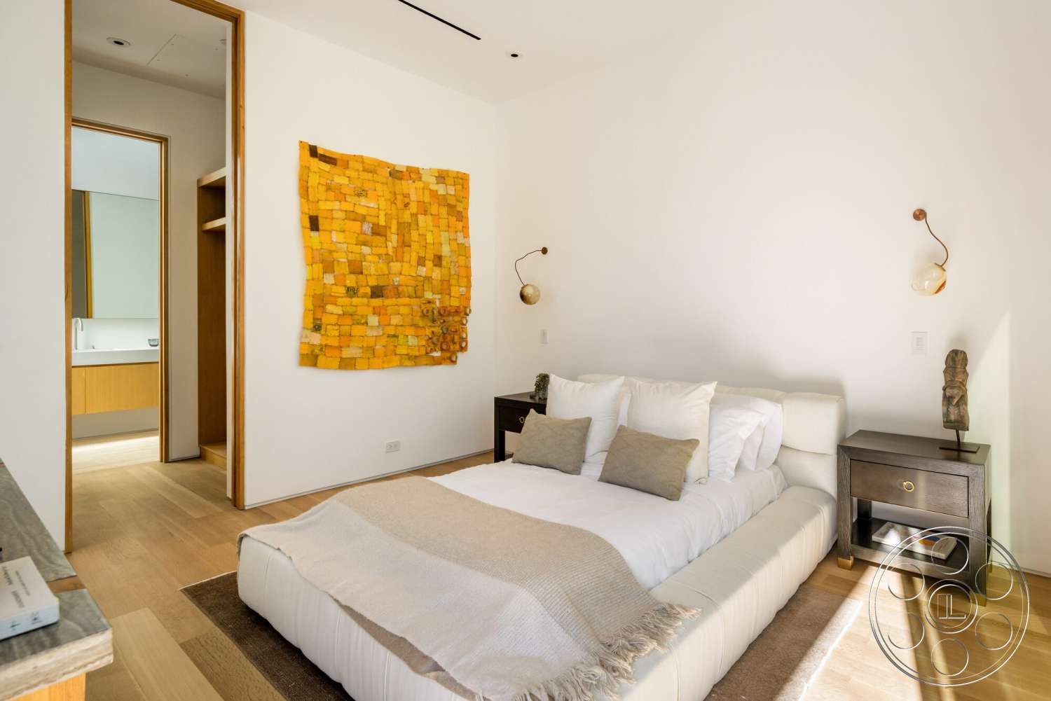 Modern 529 - minimalist decor, neutral color palette, plush bedding, modern lighting fixtures, floor-to-ceiling windows, decorative throw pillows, dark wood nightstand, wall-mounted sconces, hardwood bedroom floors, white painted walls, exposed wood paneling, open doorway to bathroom, upholstered bed frame, textile wall art