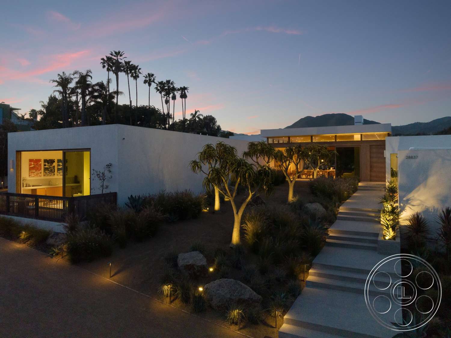 Modern 529 - exterior, white stucco walls, palm trees, large glass windows, dark wood accents, rectangular planters, landscape lighting, mountain view, open patio, concrete walkway, wooden front door, flat roof design, modern garden landscaping, porch seating area