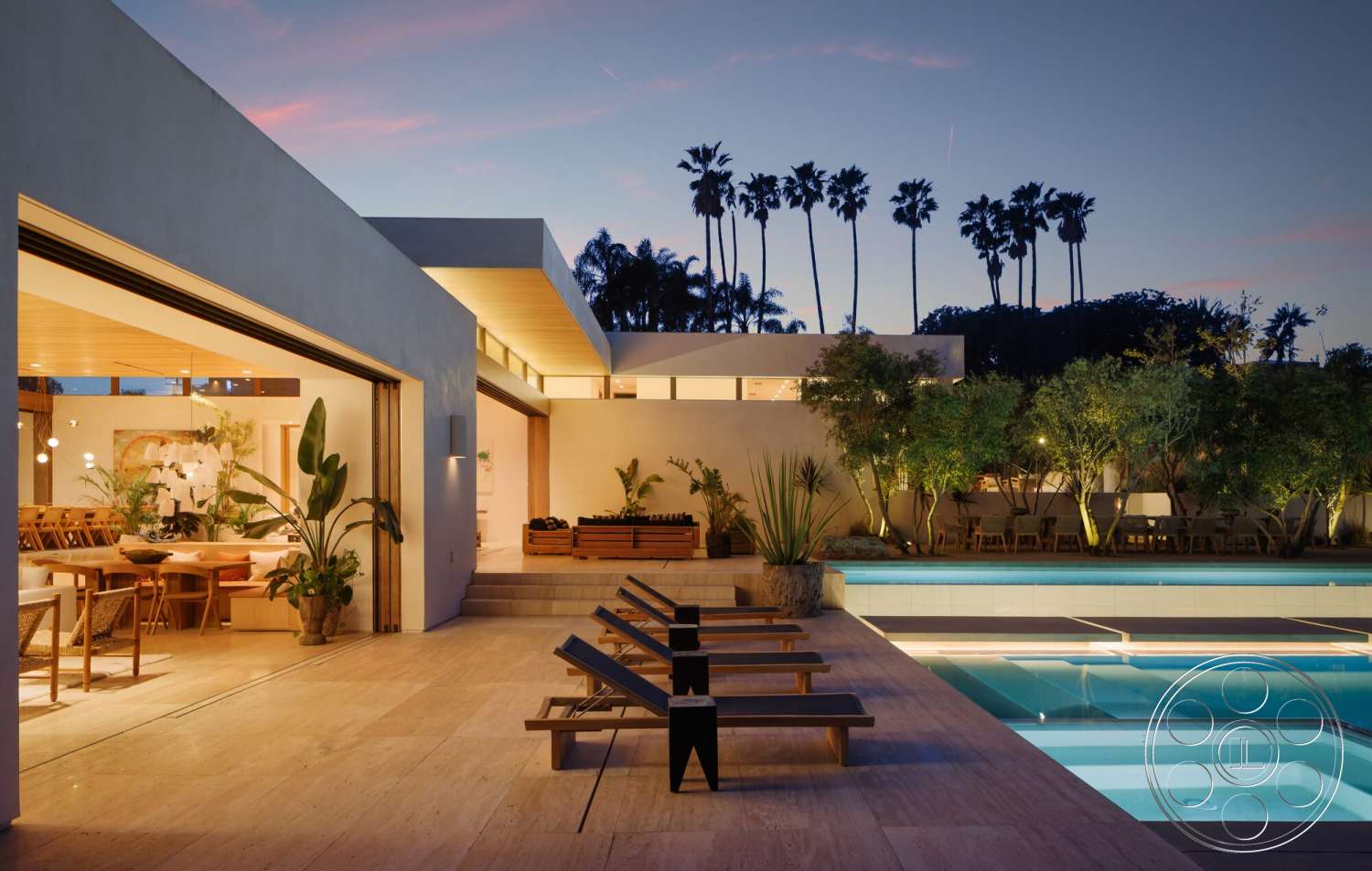 Modern 529 - exterior, landscaped garden, modern architecture, sliding glass doors, open-concept living space, outdoor lounge area, stucco walls, concrete pool deck, rectangular pool, wood beam ceiling, built-in planters, limestone patio flooring, palm tree backdrop, dining area with natural light, evening lighting ambiance