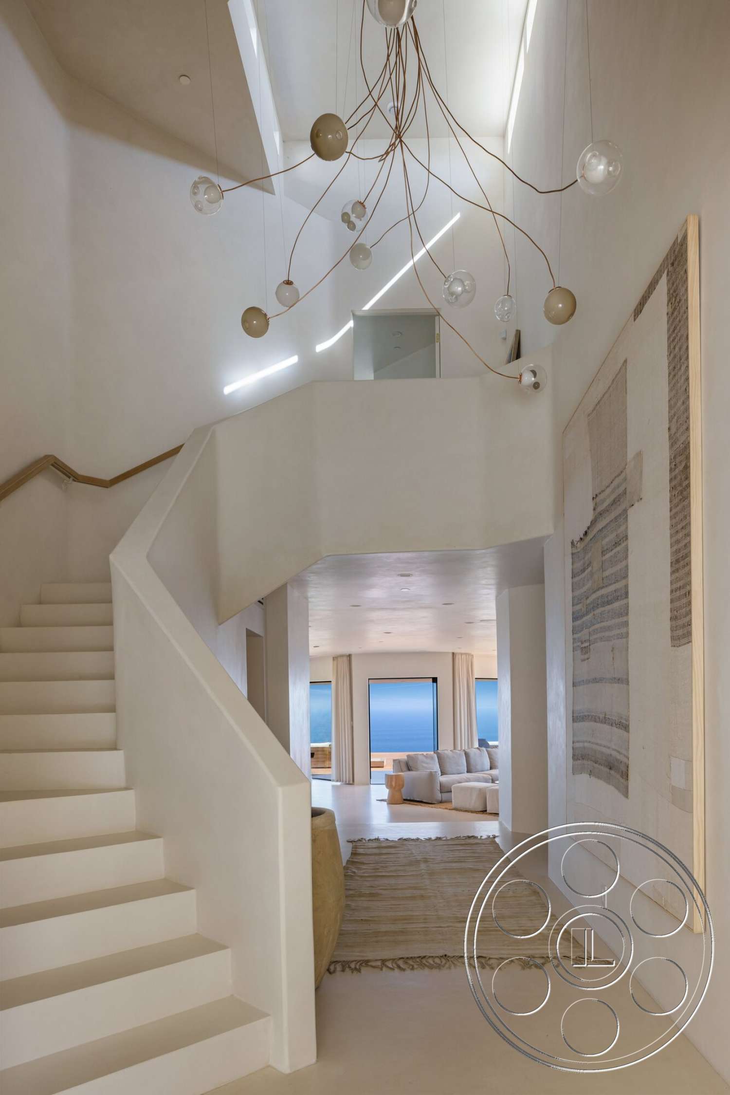 Modern 528 - textured area rug, open floor plan, modern pendant lighting, smooth concrete flooring, white plaster walls, tall ceilings, floating staircase, large panoramic windows, architectural detail lighting