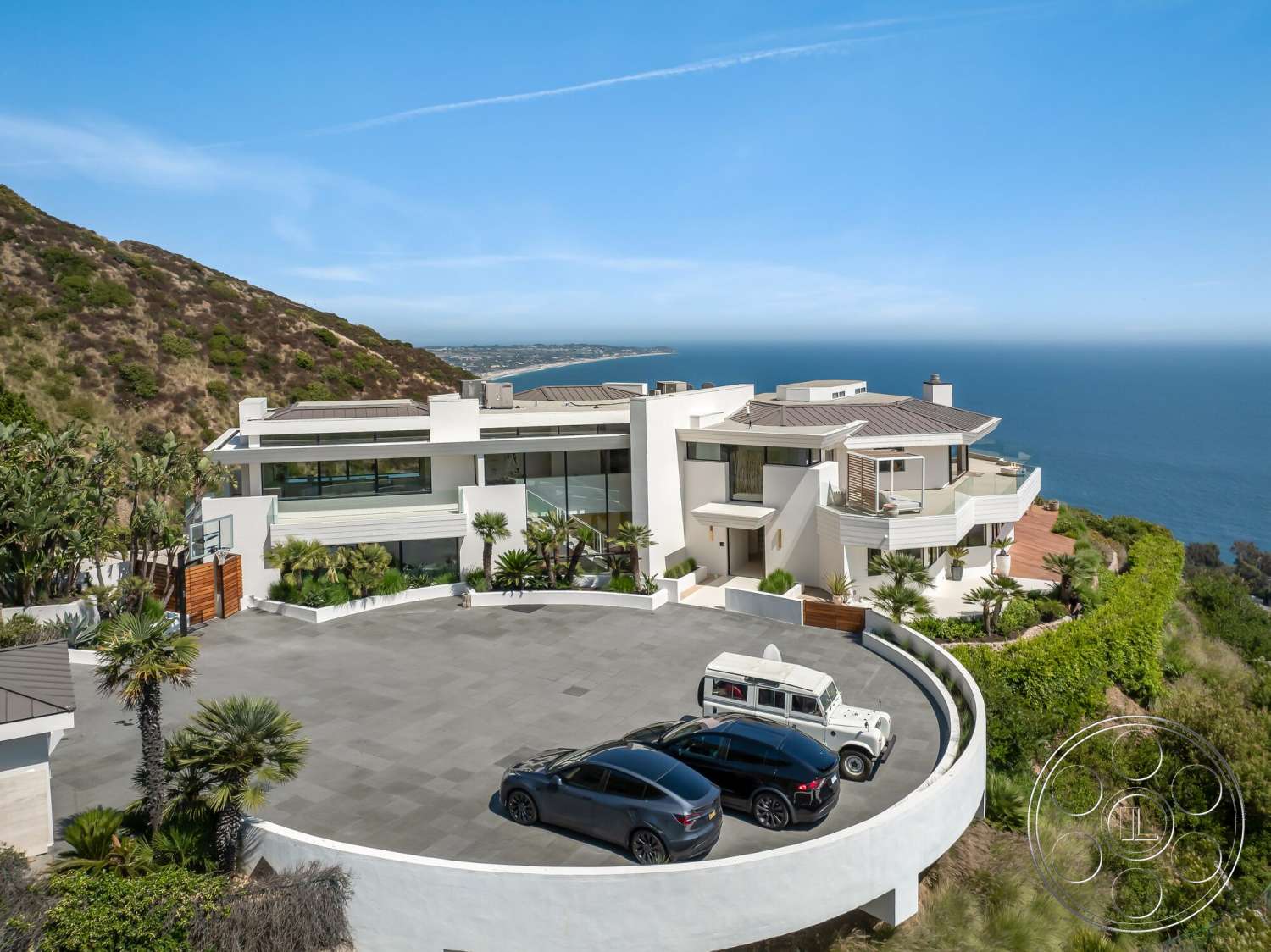 Modern 528 - exterior, landscaped garden, flat roof, outdoor patio, glass windows, basketball court, concrete driveway, curved driveway, stucco walls, large sliding doors, minimalist architectural style, modern architectural details, oceanfront view, natural hillside setting