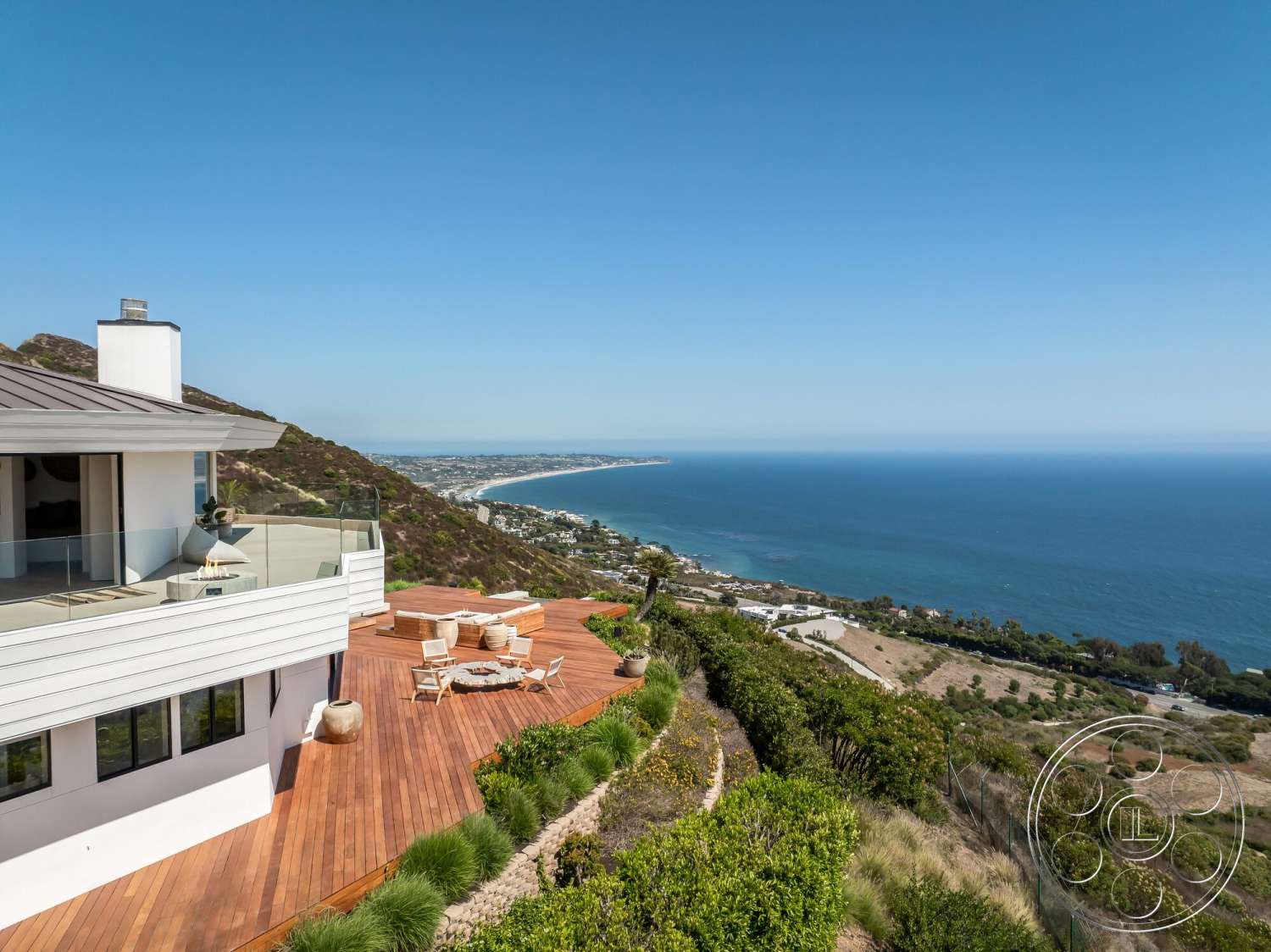 Modern 528 - exterior, contemporary architecture, ocean view, ceramic planter, landscaped garden beds, wood deck patio, outdoor lounge seating, glass balcony railing, sloped hillside location, white lap siding walls