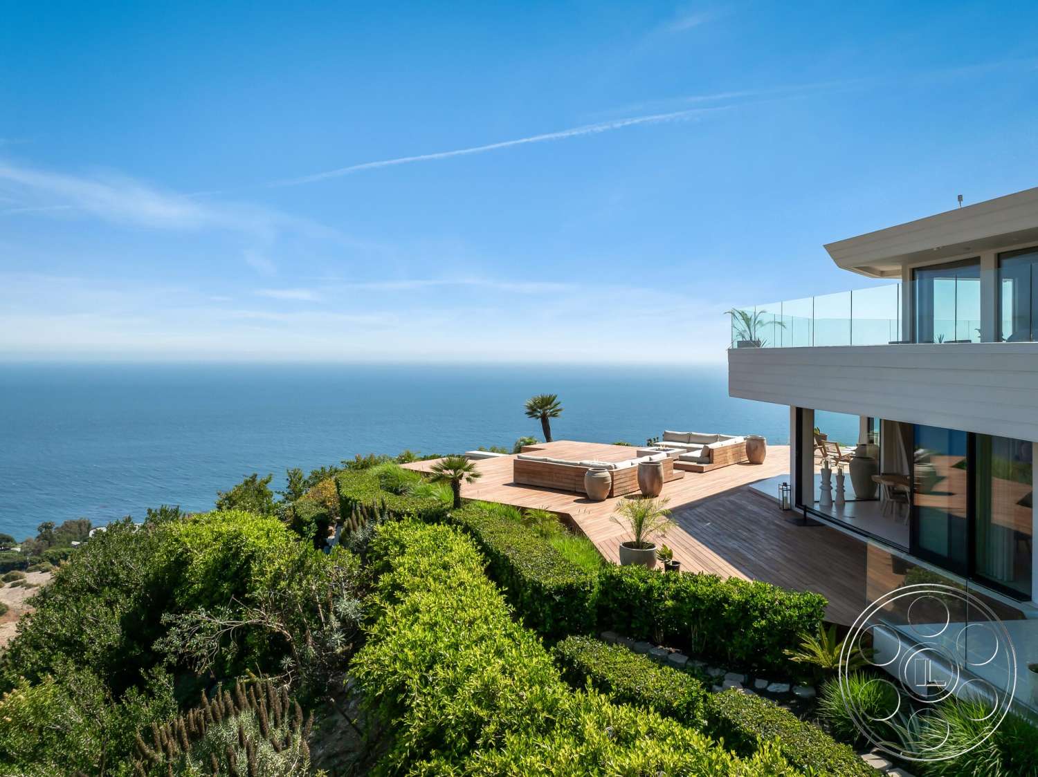 Modern 528 - exterior, landscaped garden, modern architecture, low-maintenance plants, outdoor seating area, glass railing, coastal view, horizontal wood siding, contemporary home design, wood deck patio, oceanfront property, sunny hillside location, overhanging roof, open panoramic view, stepped landscaping