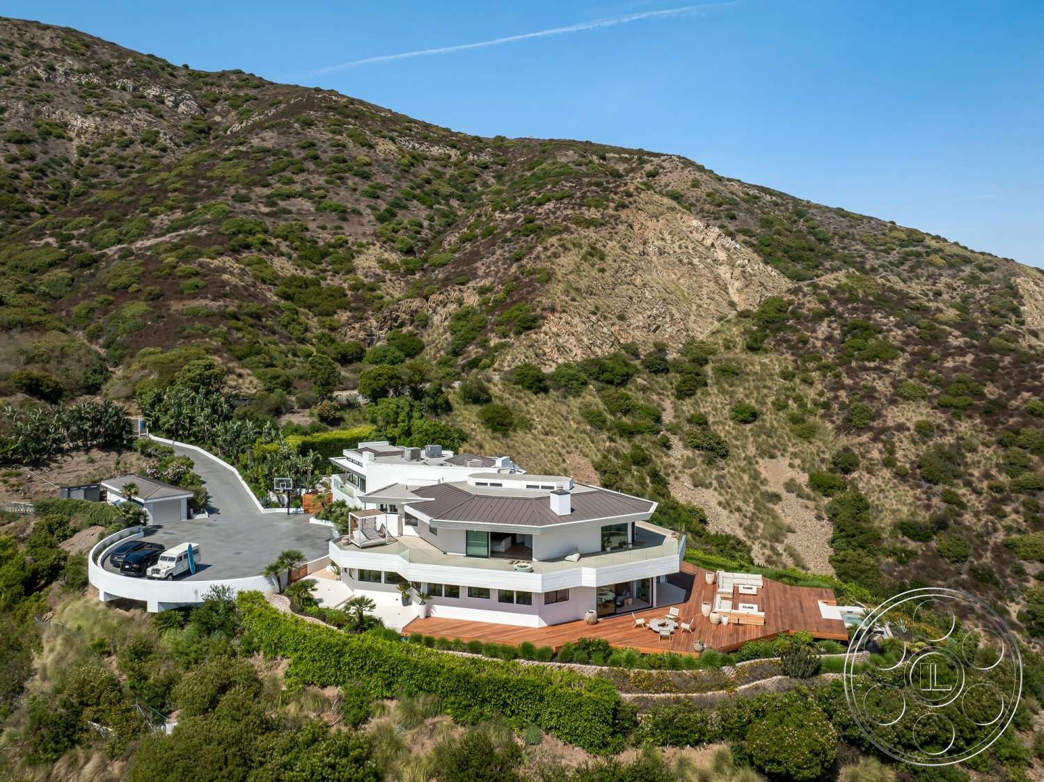 Modern 528 - exterior, landscaped garden, modern architecture, outdoor seating area, floor-to-ceiling windows, multi-level structure, balcony, curved driveway, large overhangs, flat roof design, mountain view setting, concrete foundation, wooden deck patio, glass railing details, surrounding hillside vegetation