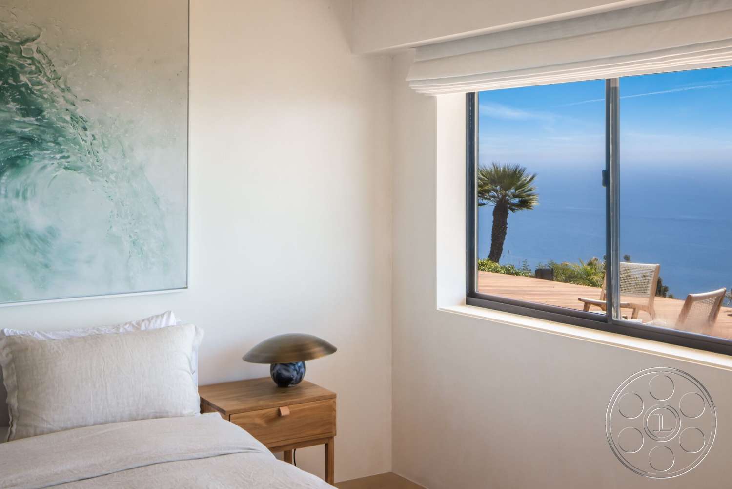 Modern 528 - minimalist design, floor-to-ceiling windows, decorative lamp, ocean view, textured plaster walls, palm tree view, wood nightstand, hardwood bedroom floors, framed ocean wave artwork, bedding with neutral tones