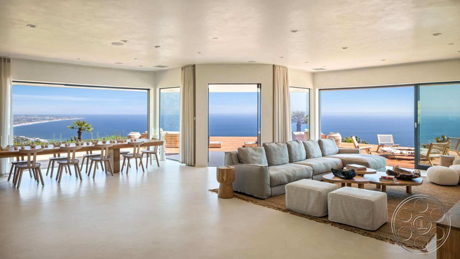 Modern 528 - neutral color palette, modern architecture, wooden coffee table, open floor plan, modern light fixtures, large floor-to-ceiling windows, textured wall treatment, soft fabric sofa, natural fiber area rug, landscape ocean view, minimalist dining table, light-colored concrete flooring, wood dining table with wooden chairs, sliding glass doors to exterior patio, expansive living space