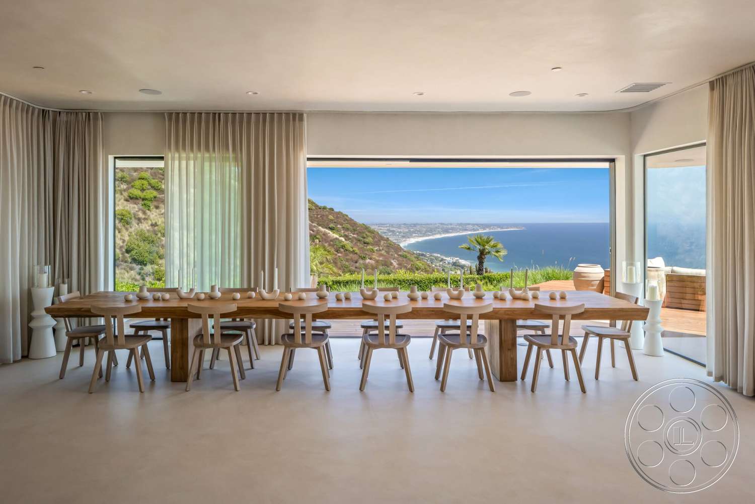 Modern 528 - minimalist design, open concept layout, floor-to-ceiling windows, natural wood dining table, modern architectural style, ocean view, mountain backdrop, bright and airy atmosphere, wooden dining chairs, interior dining area, light-colored concrete flooring, curtain wall with sheer drapes